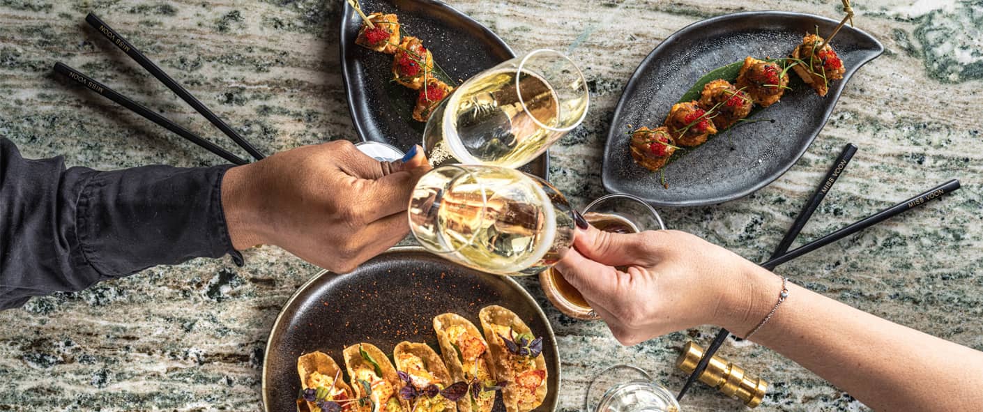 Två personer som skålar över bord med mat