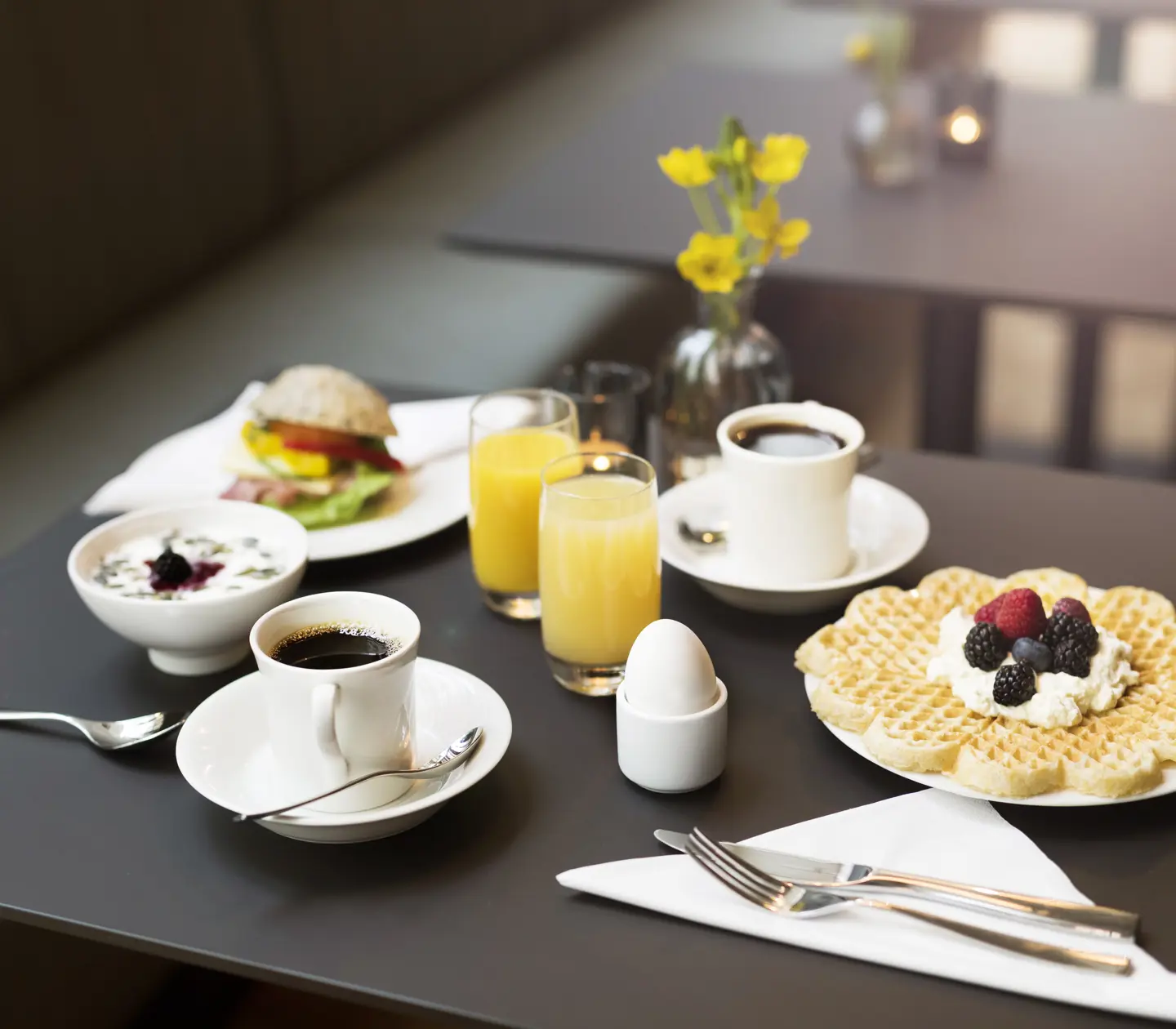 Breakfast laid out on the table with juice, coffee and waffles