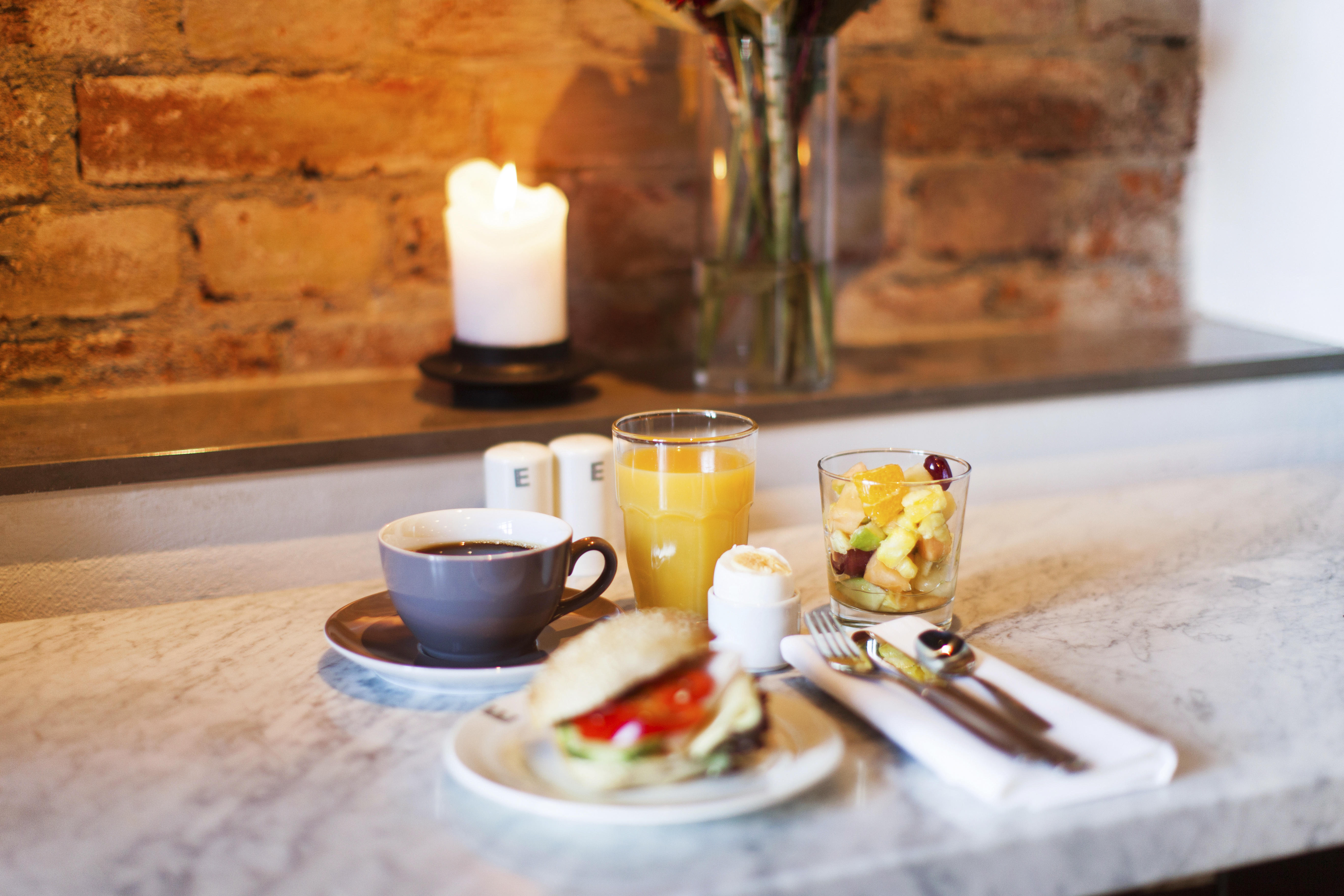 Hotellfrukost i Köping som inkluderar bland annat en kopp kaffe, juice och en macka. 