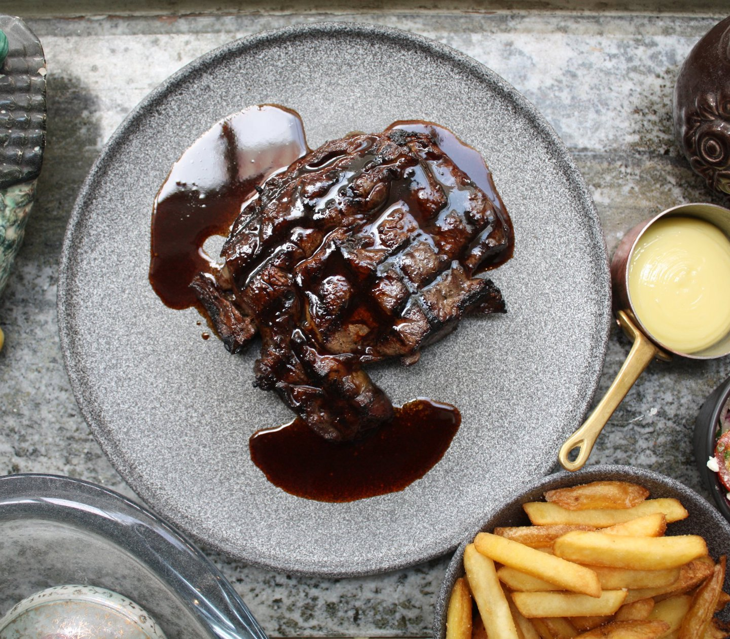 A steak served with fries and sauce
