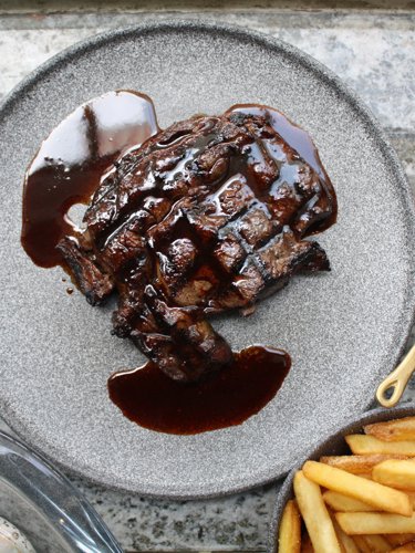 A steak served with fries and sauce