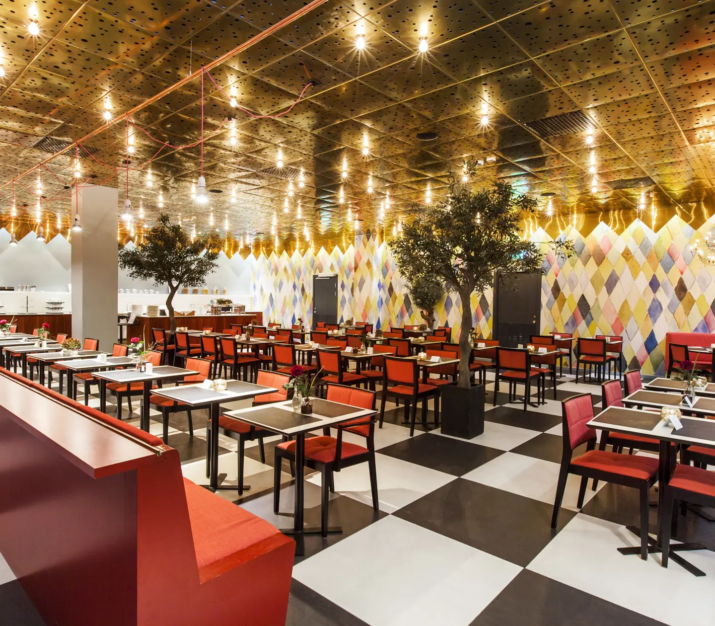 Restaurang med röda stolar och rutigt golv i svart och vitt