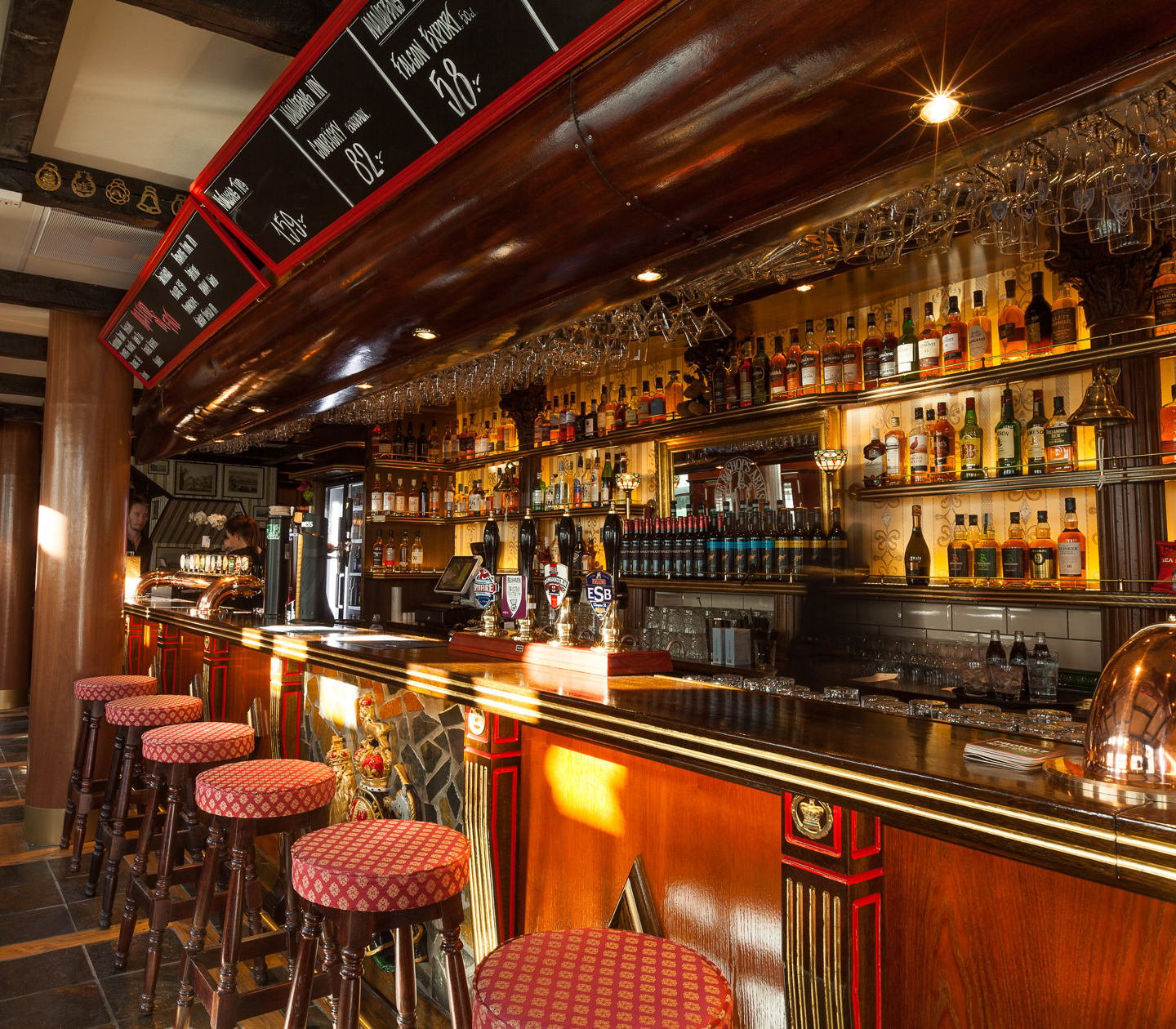 Klassisk engelsk pubmiljö med bar, mycket flaskor och barstolar