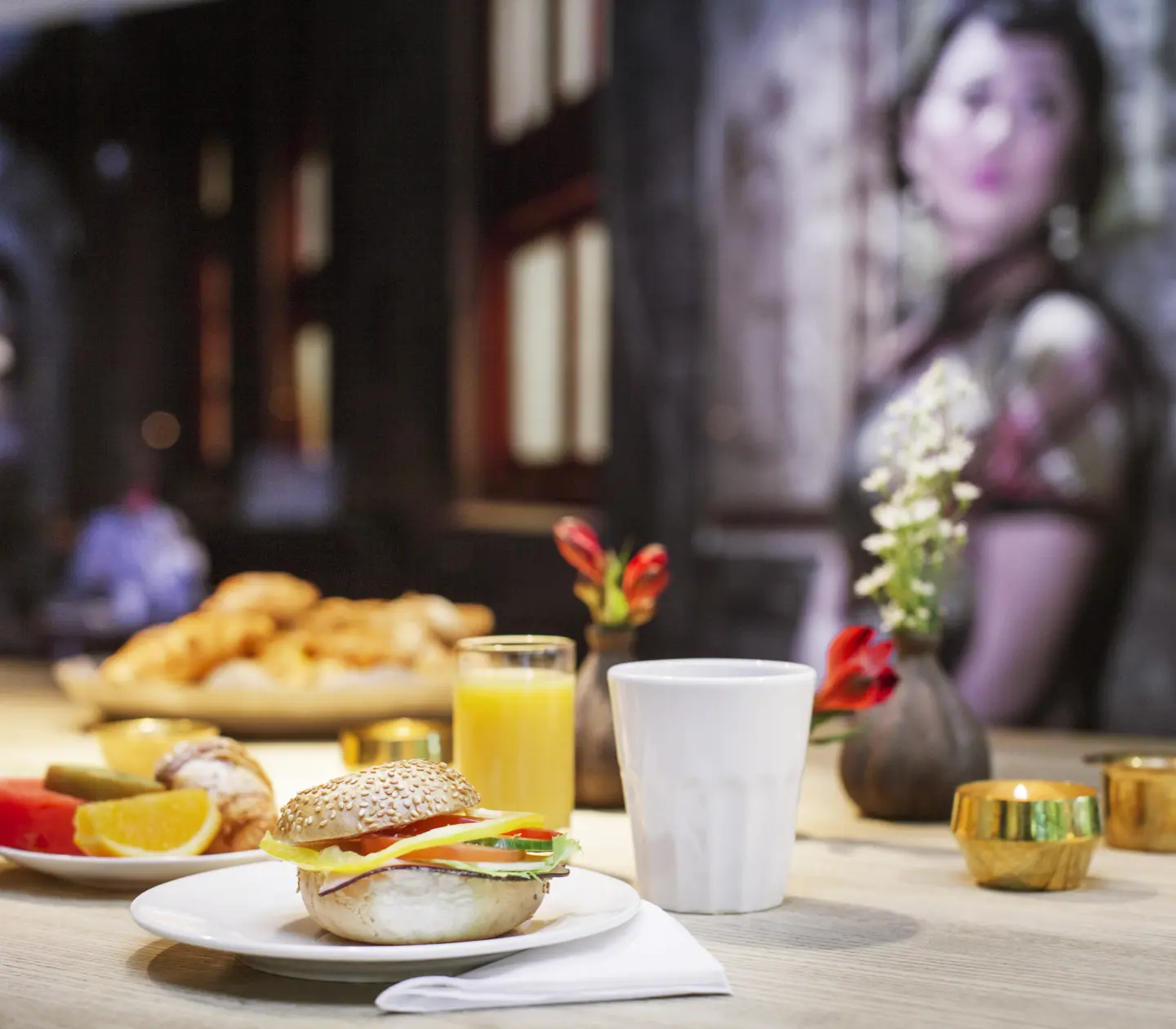 Hotel breakfast with a sandwich, fruits, juice and coffee