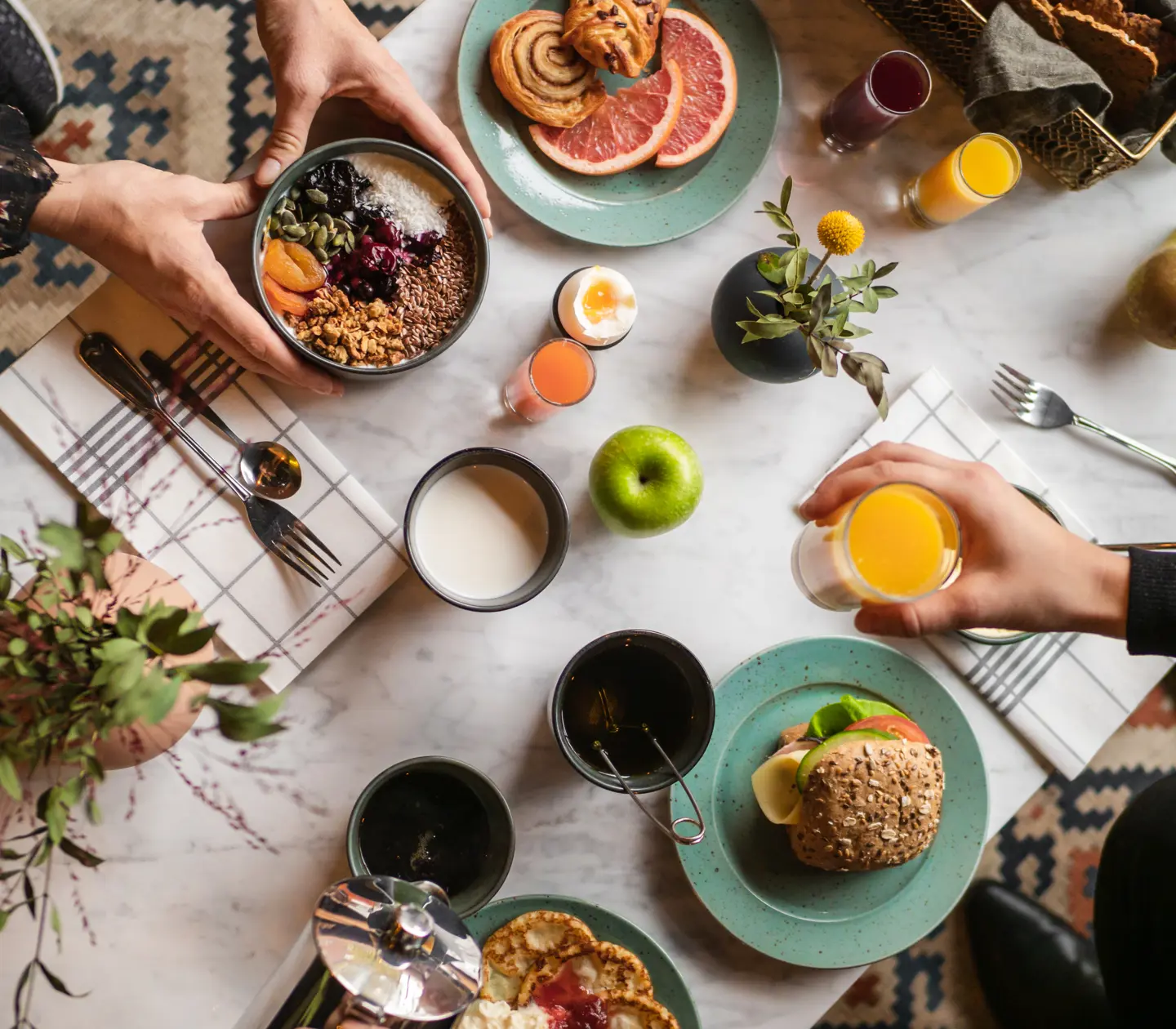 Två personer med en stor varierad frukost framför sig