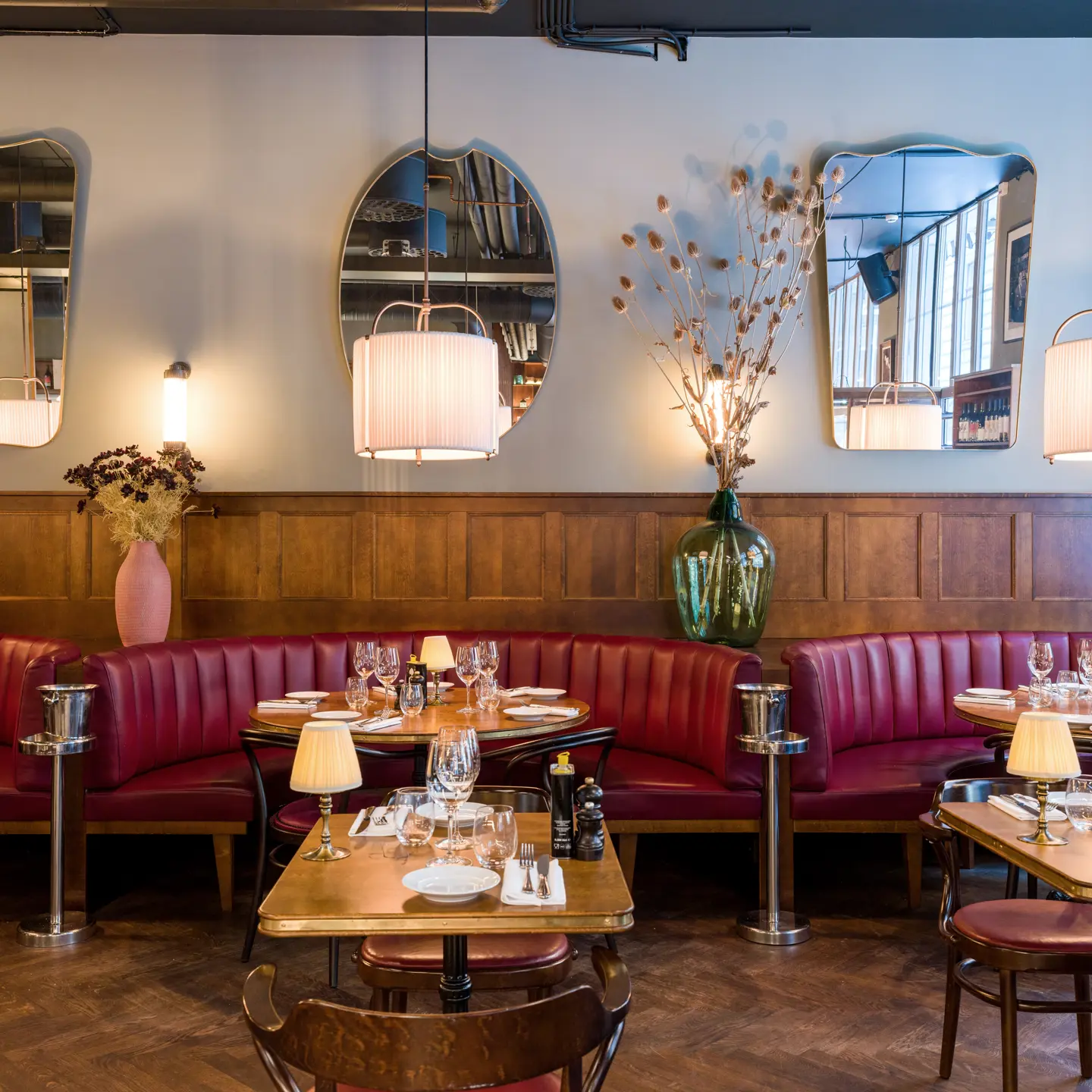 En restaurang med träinredning och bås med skinnsoffor