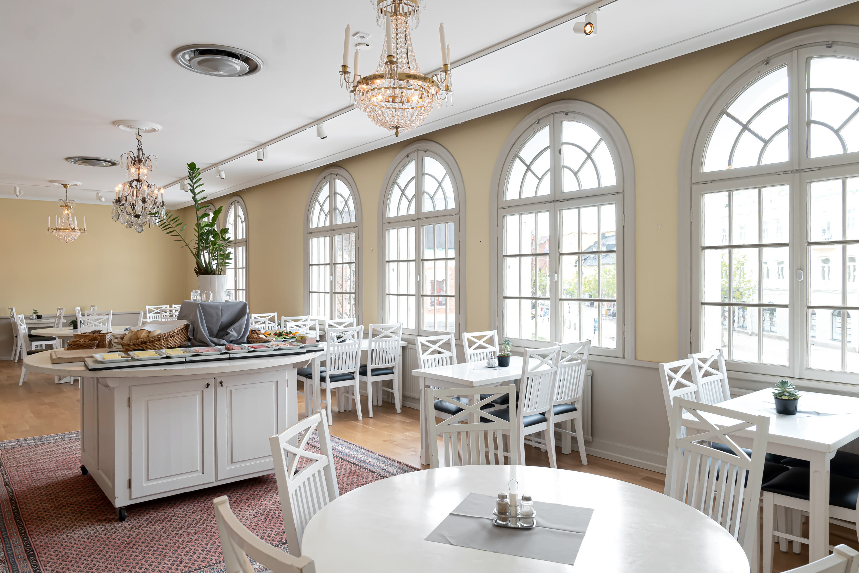 Ljus restaurang med stora fönster och kristallkronor