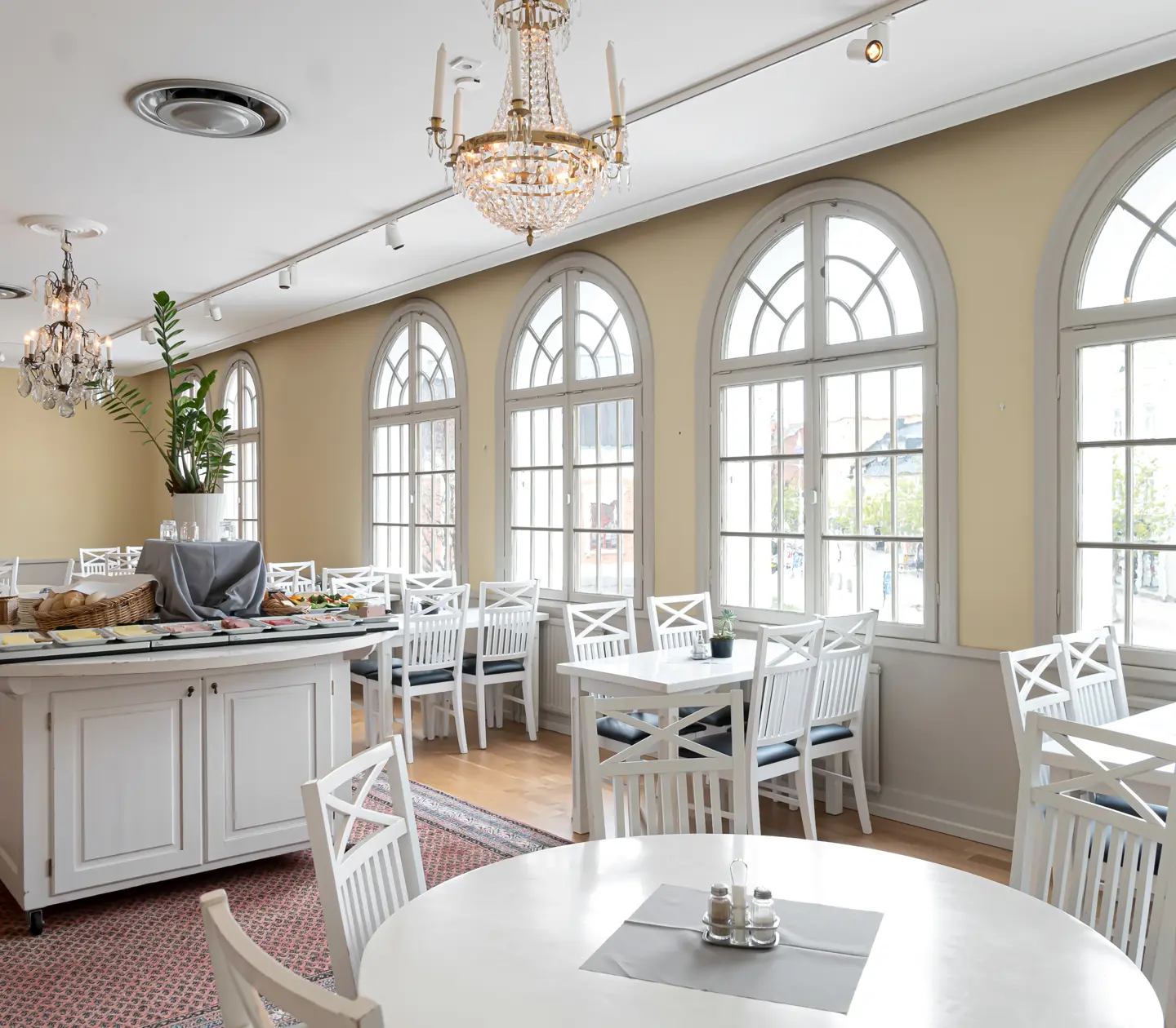 Ljus restaurang med stora fönster och kristallkronor