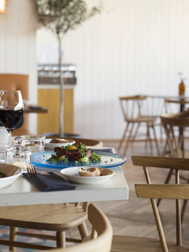 Two dishes served in a restaurant with wooden chairs