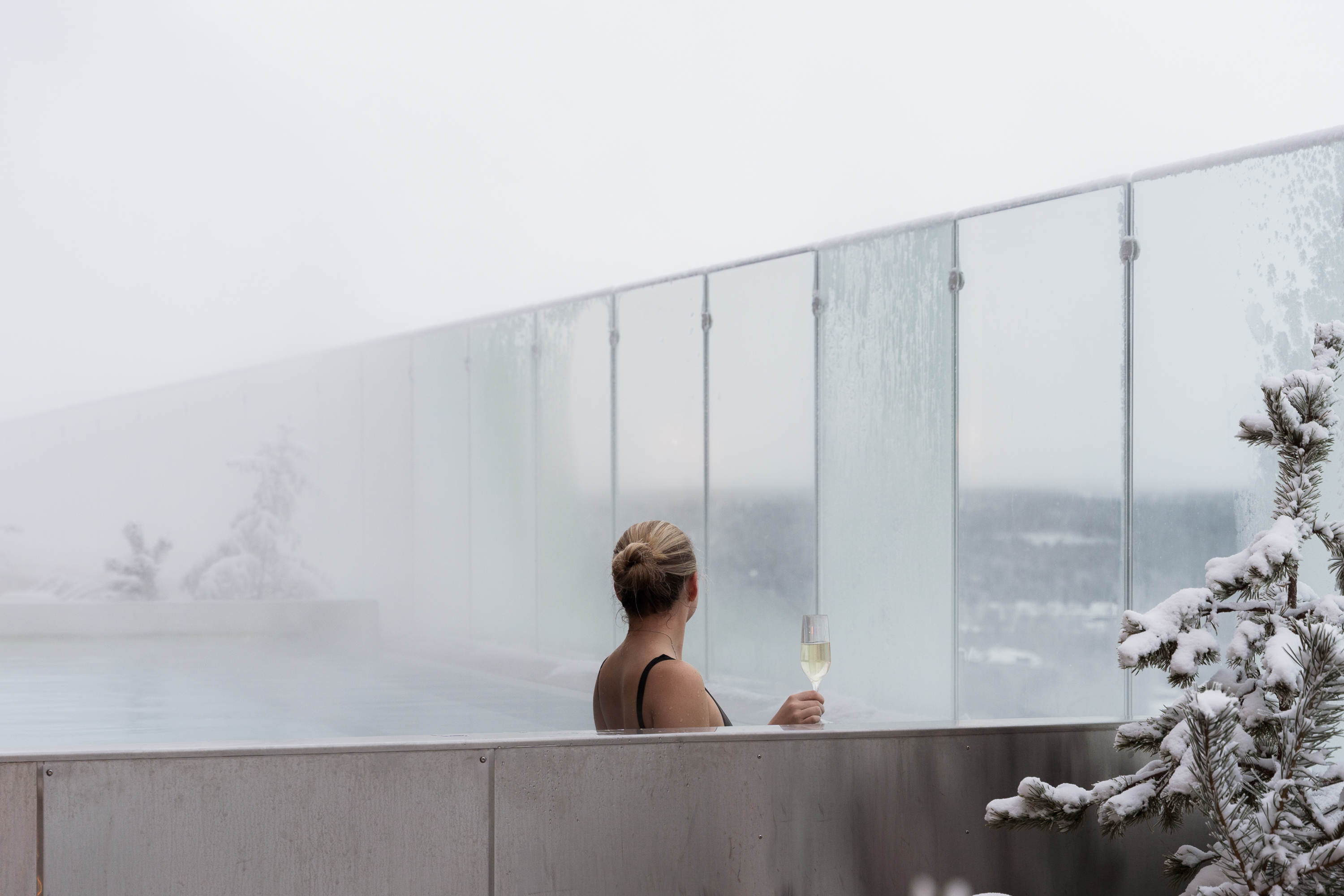 Kvinna i utomhuspool med champagneglas