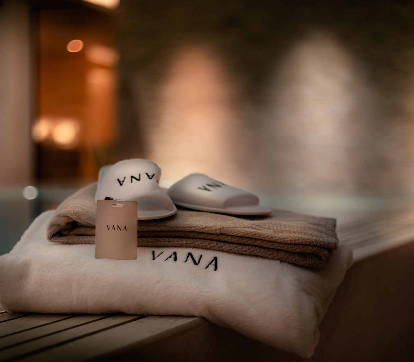 Folded bathrobe and slippers with Vana Spa logo