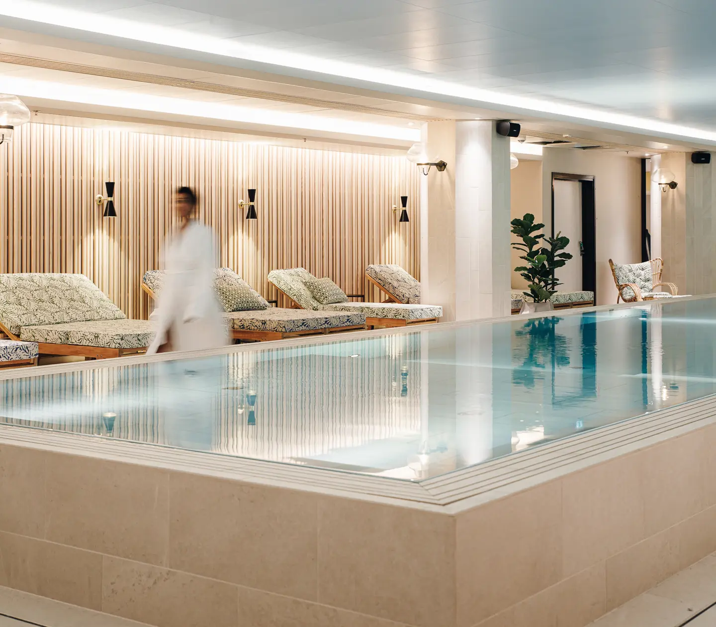 Kvinna i badrock gående längst med pool