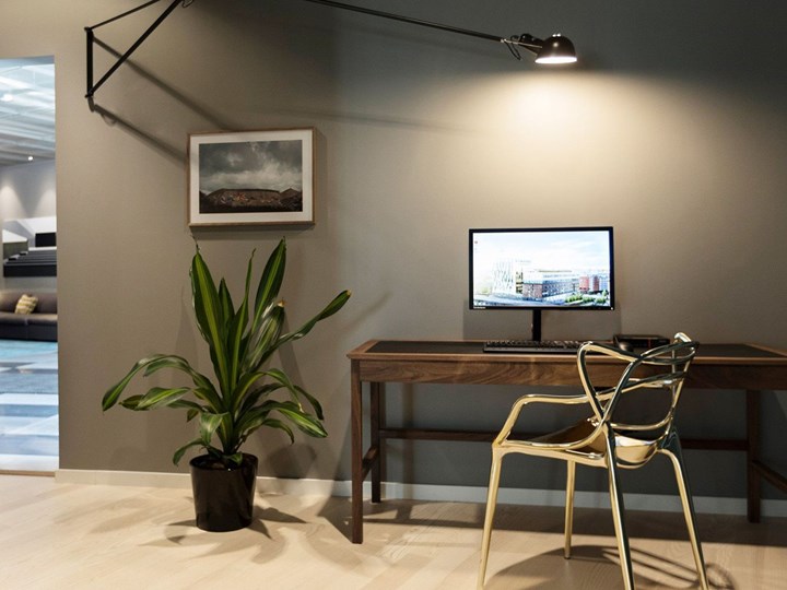 Bild på en dator på ett bord med en blomma brevid.