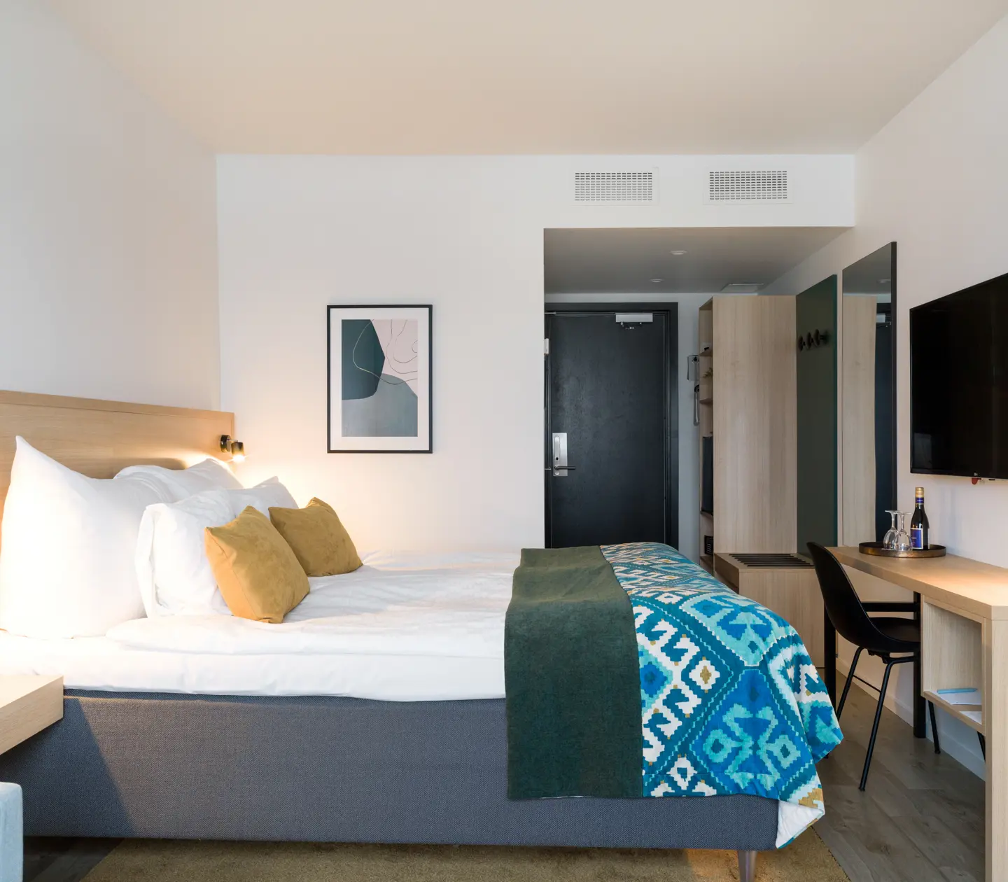 Hotellrum med dubbelsäng och skrivbord