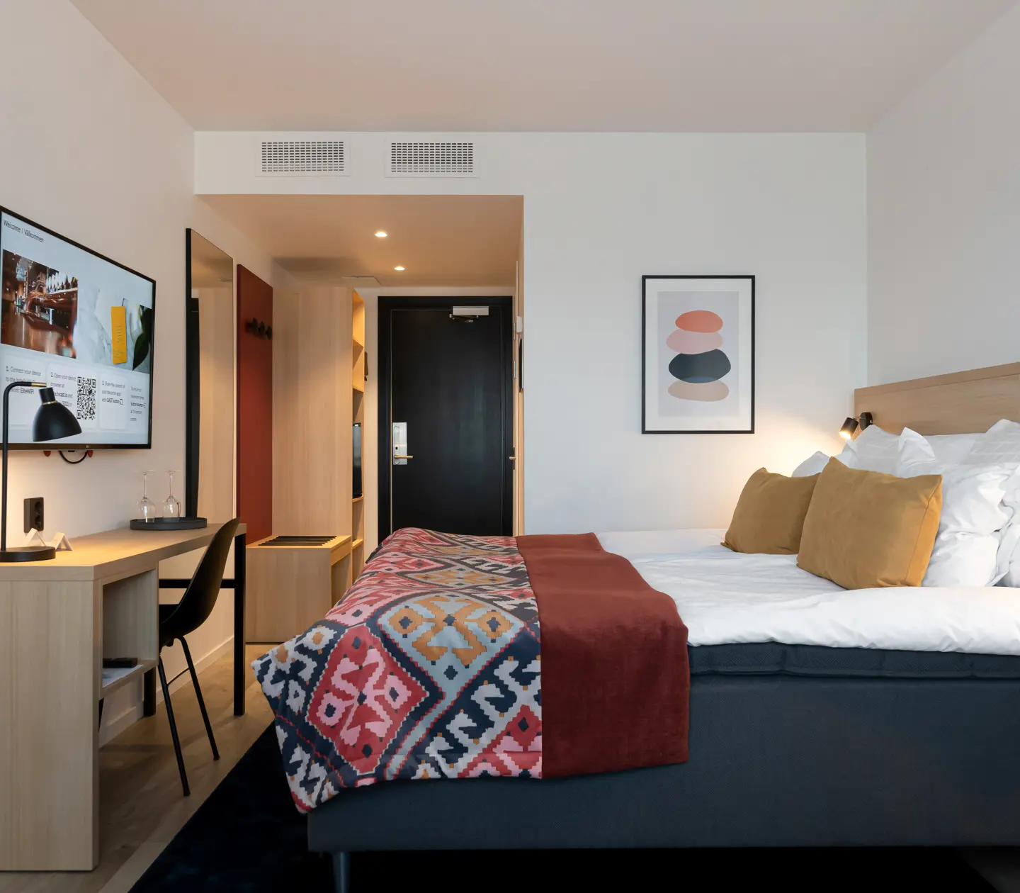Hotellrum med dubbelsäng och skrivbord
