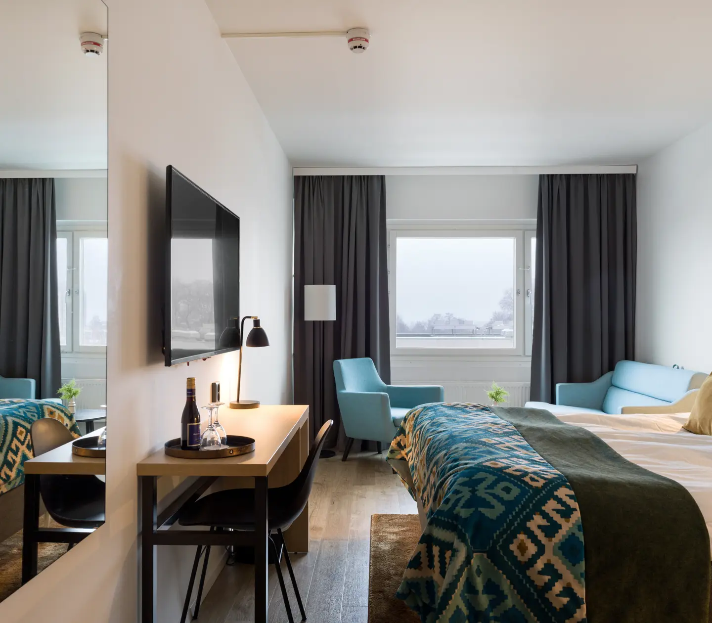 Hotellrum med dubbelsäng, bäddsoffa och skrivbord