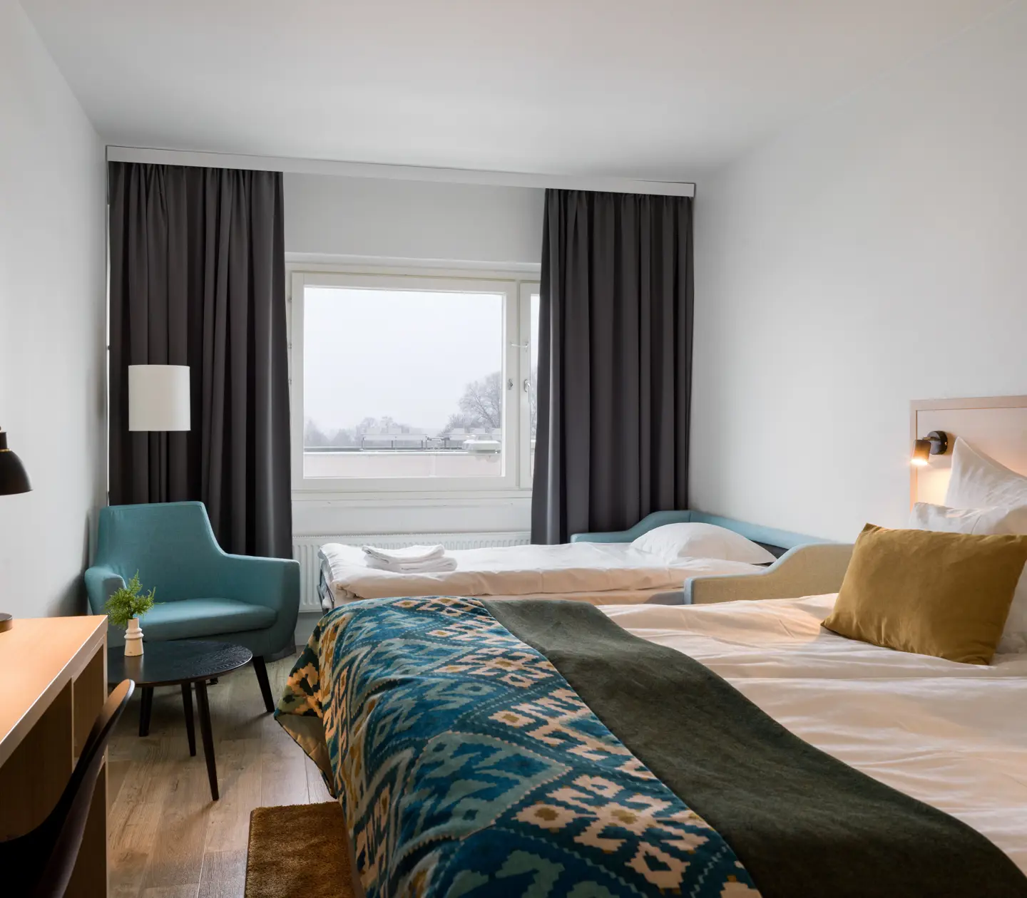 Hotellrum med dubbelsäng och utbäddad bäddsoffa