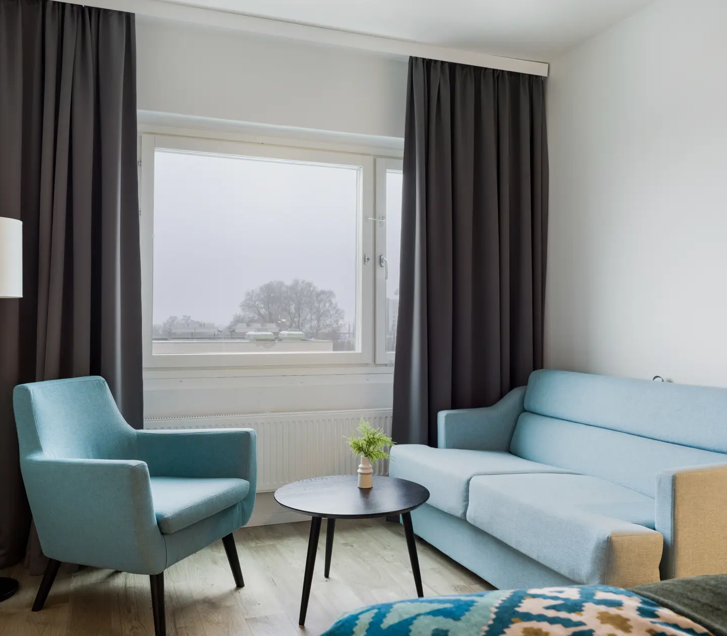 Hotellrum med soffa, fåtölj och fönster