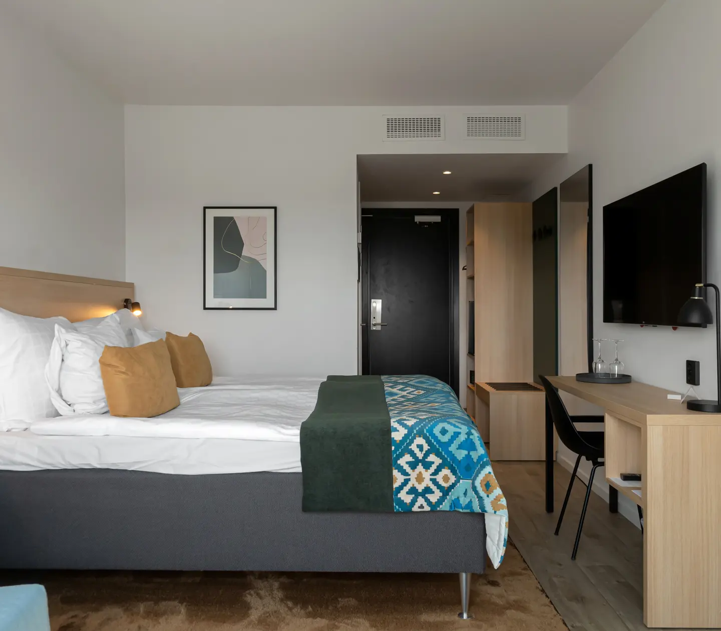 Hotellrum med dubbelsäng och skrivbord