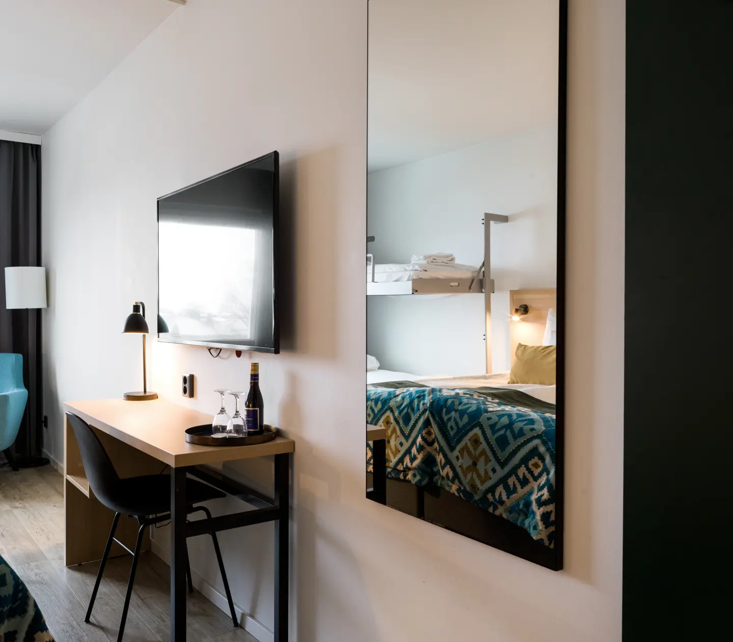 Hotellrum med spegel, skrivbord och tv