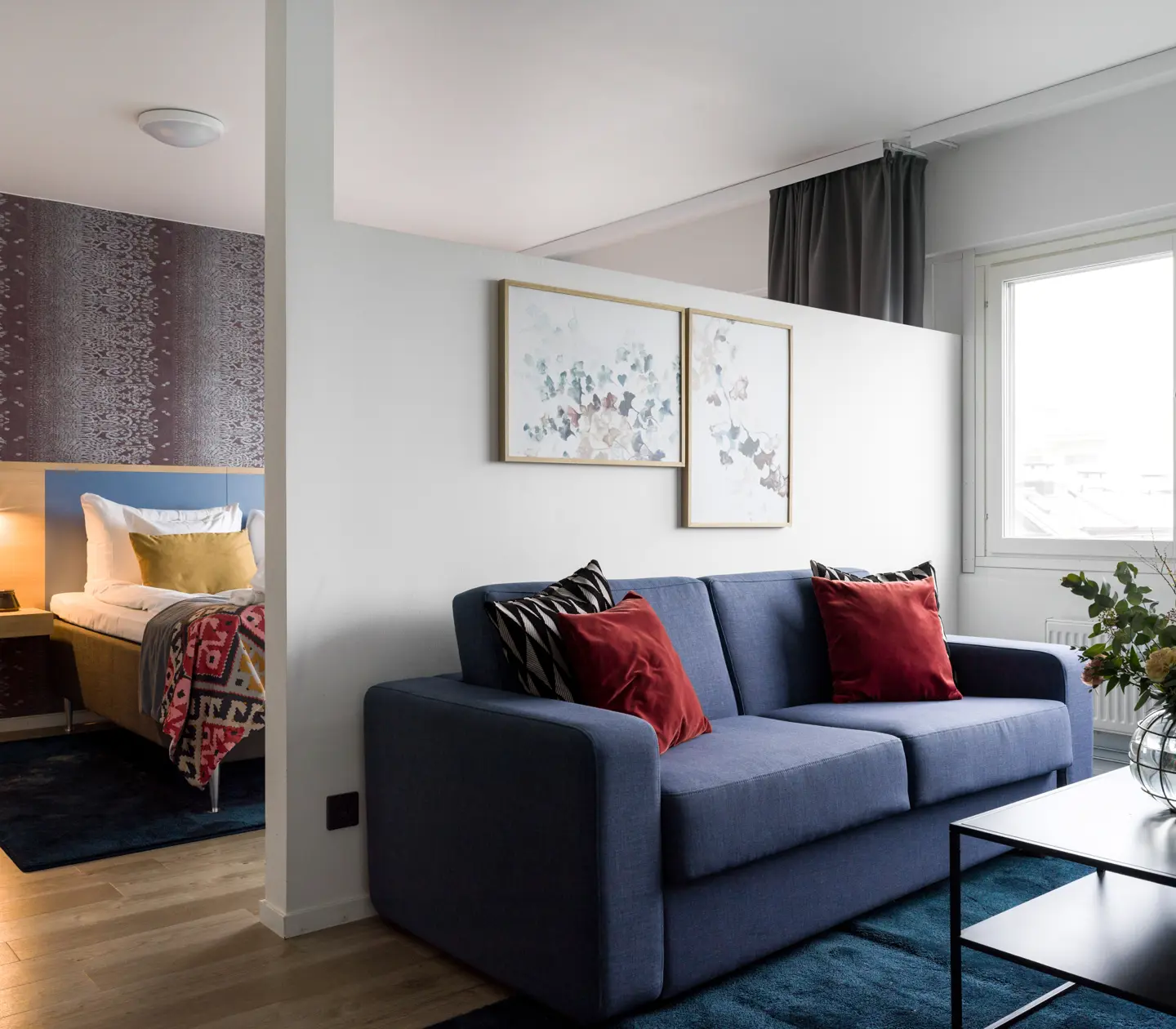 Hotellrum med bäddsoffa och blombukett