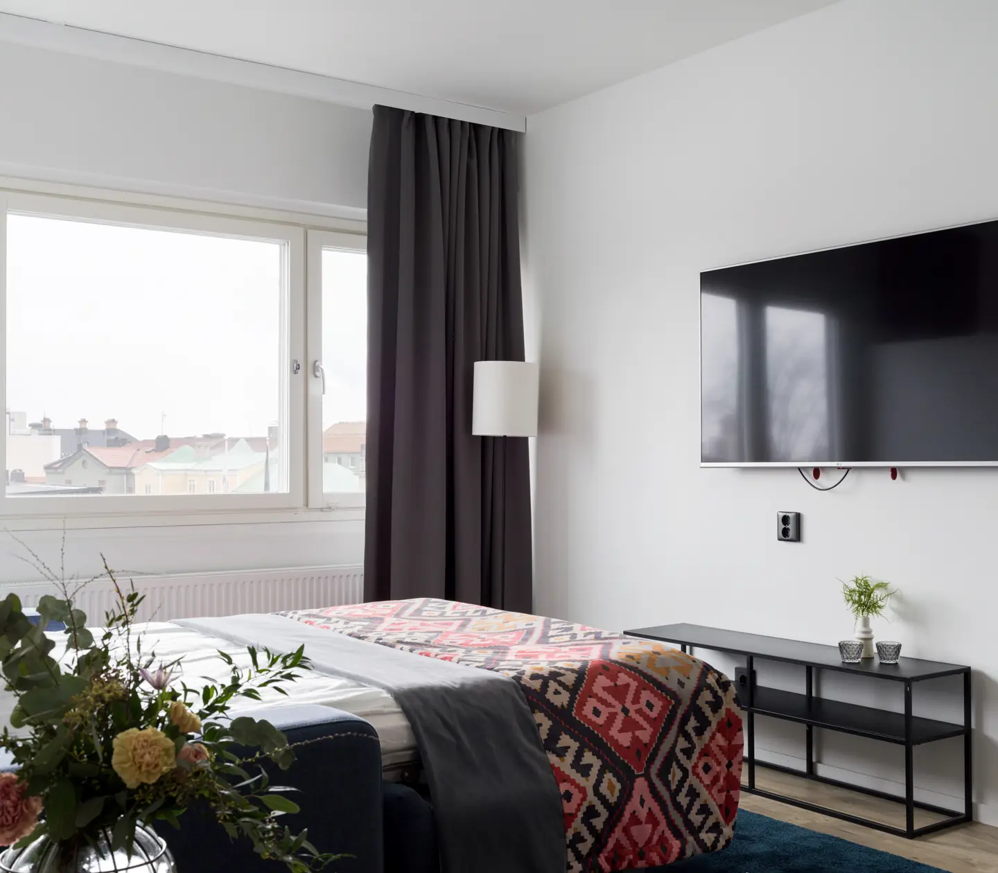 Ljust hotellrum med dubbelsäng, tv och fönster