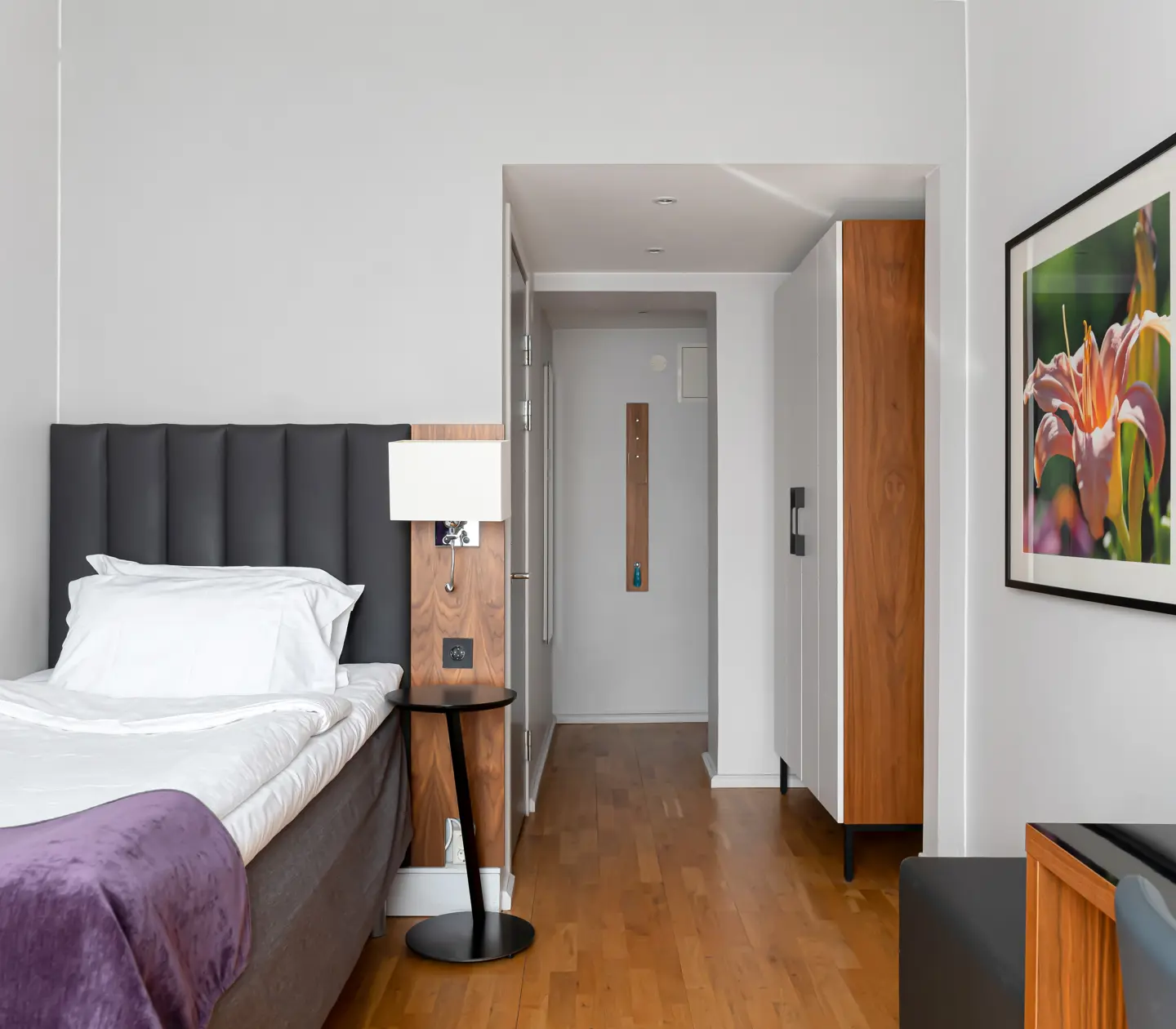 Hotellrum med enkelsäng, tavla och garderob