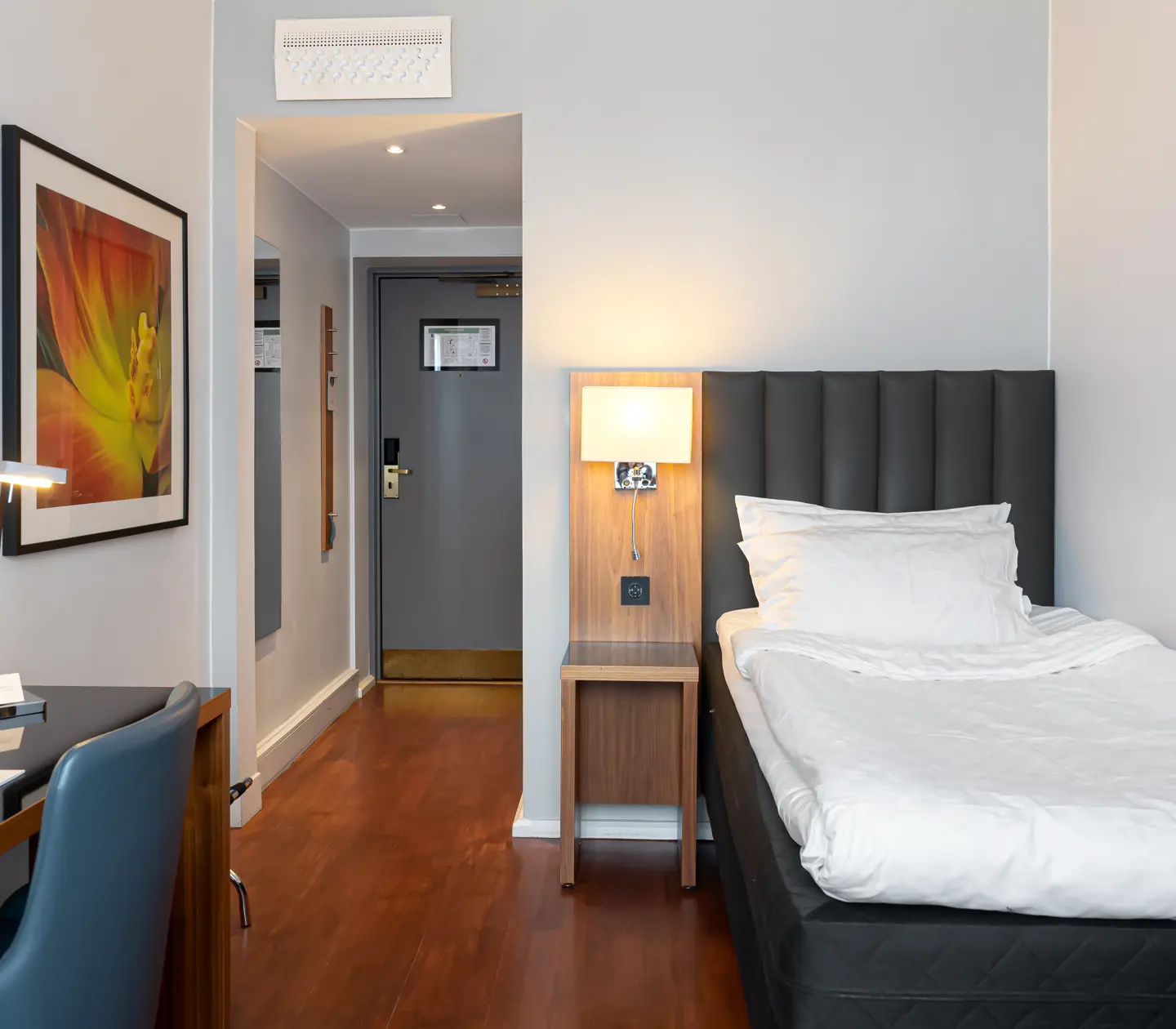 Hotellrum med enkelsäng och tavla