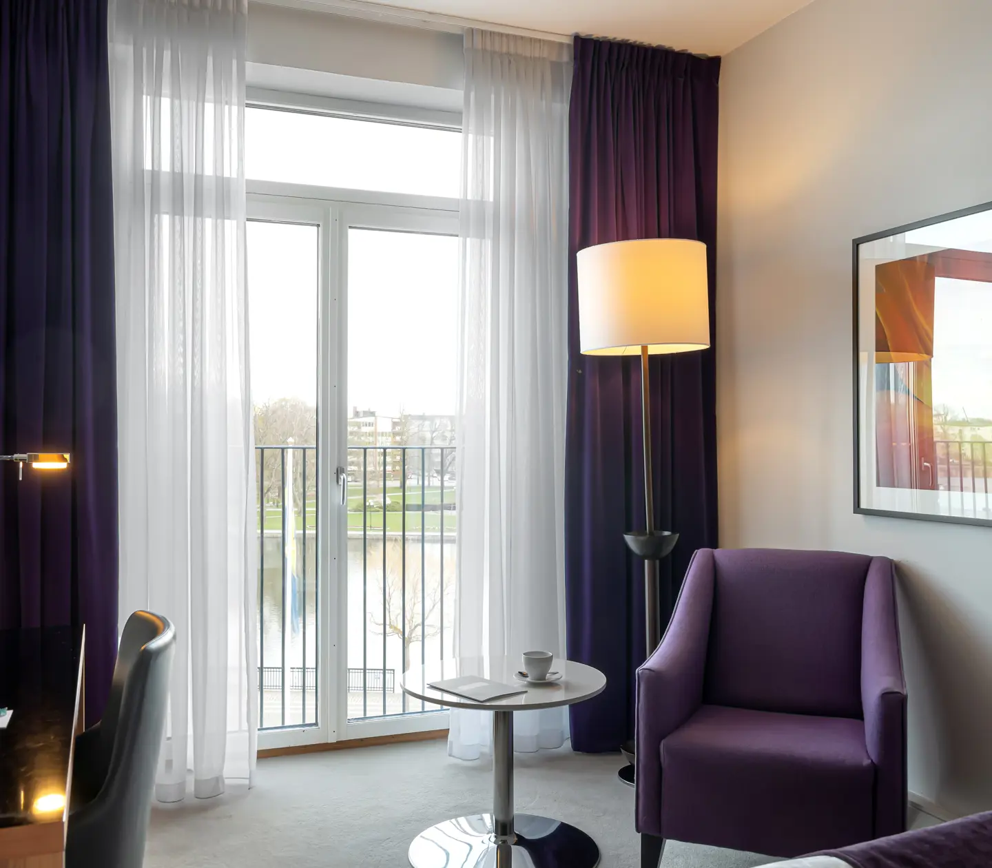 Hotellrum med fåtölj och stort fönster