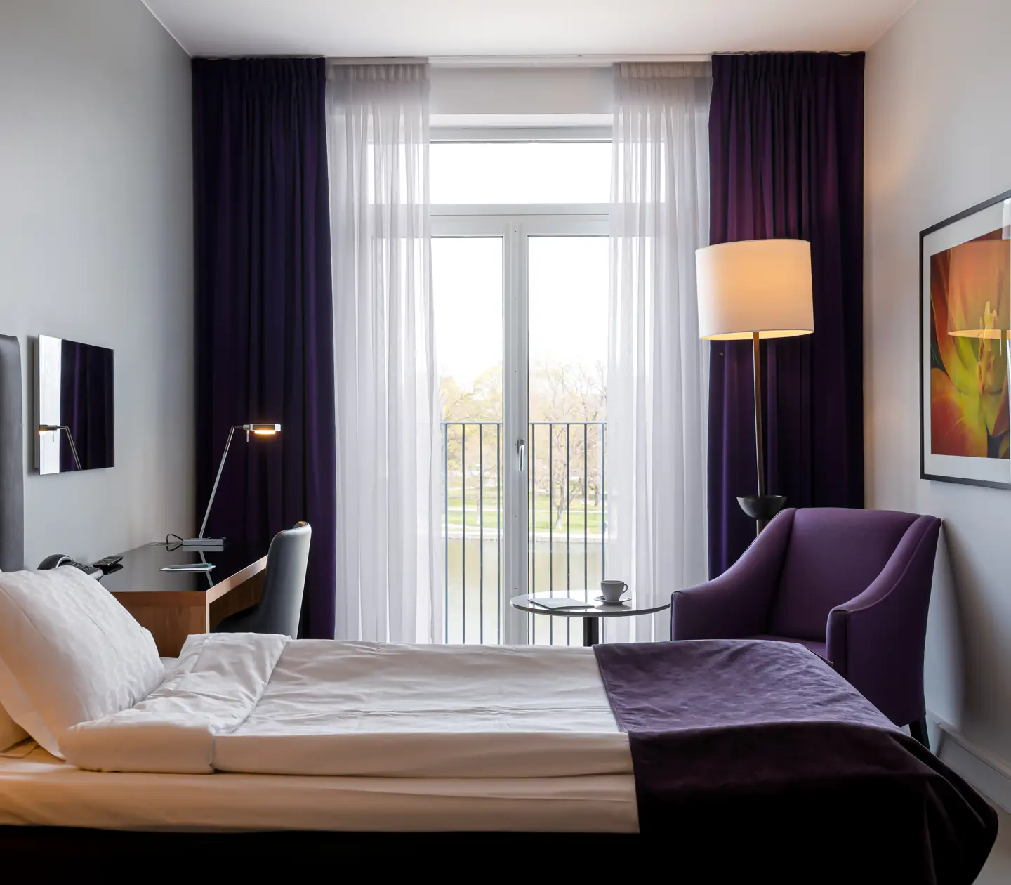 Hotellrum med enkelsäng, fåtölj och skrivbord