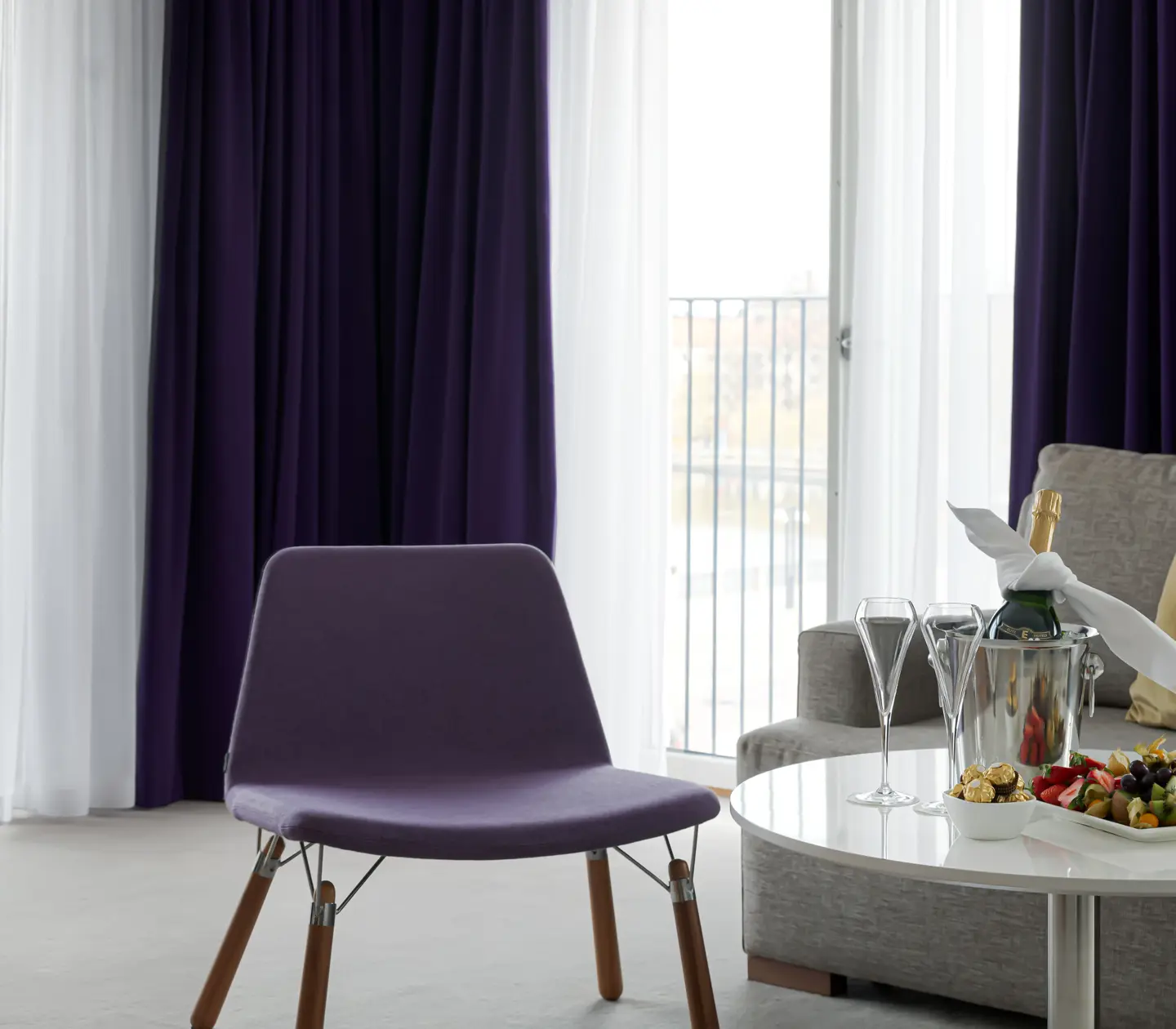 Svit med soffa, fåtölj och stora fönster