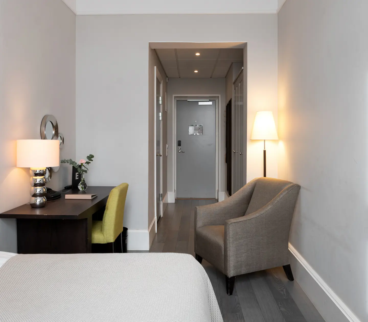 Hotellrum med säng, skrivbord och fåtölj