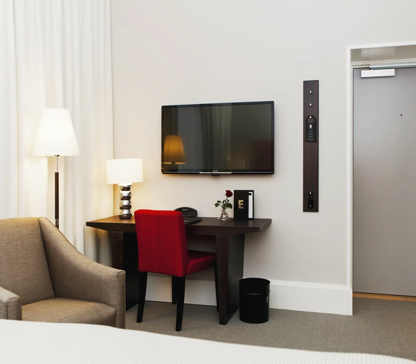 Hotellrum med skrivbord, tv och fåtölj