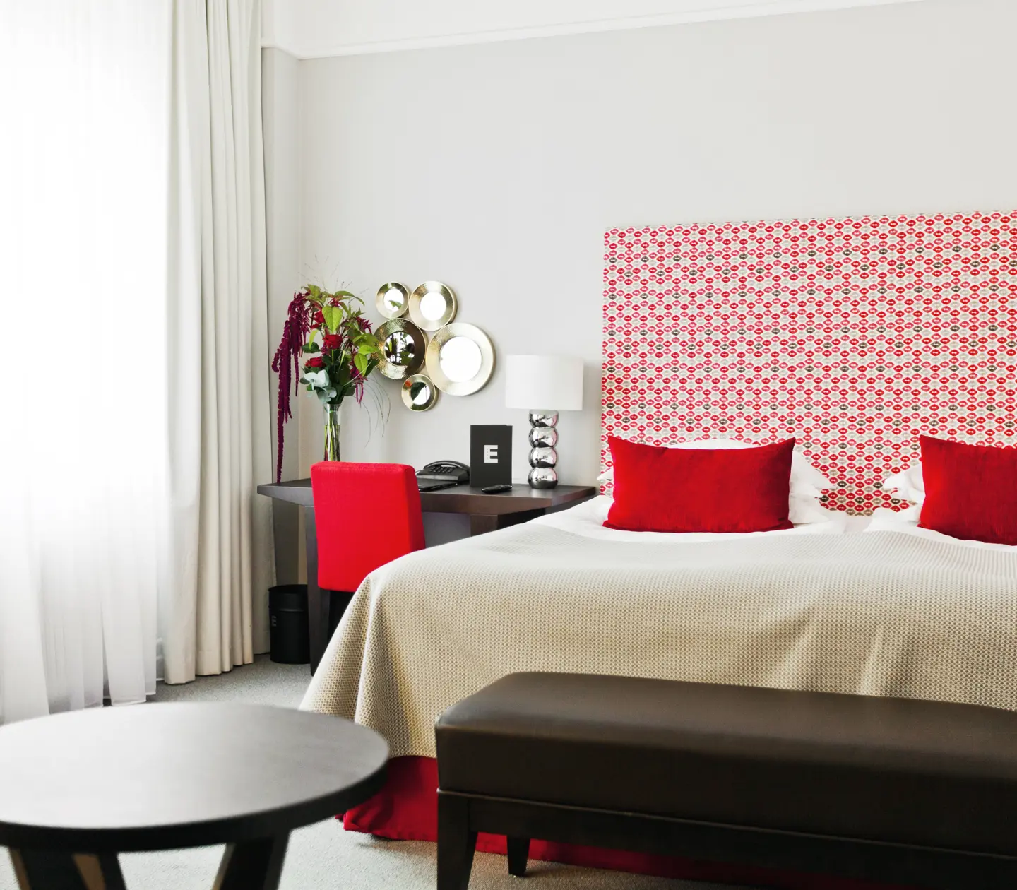 Hotellrum med dubbelsäng, skrivbord och fönster
