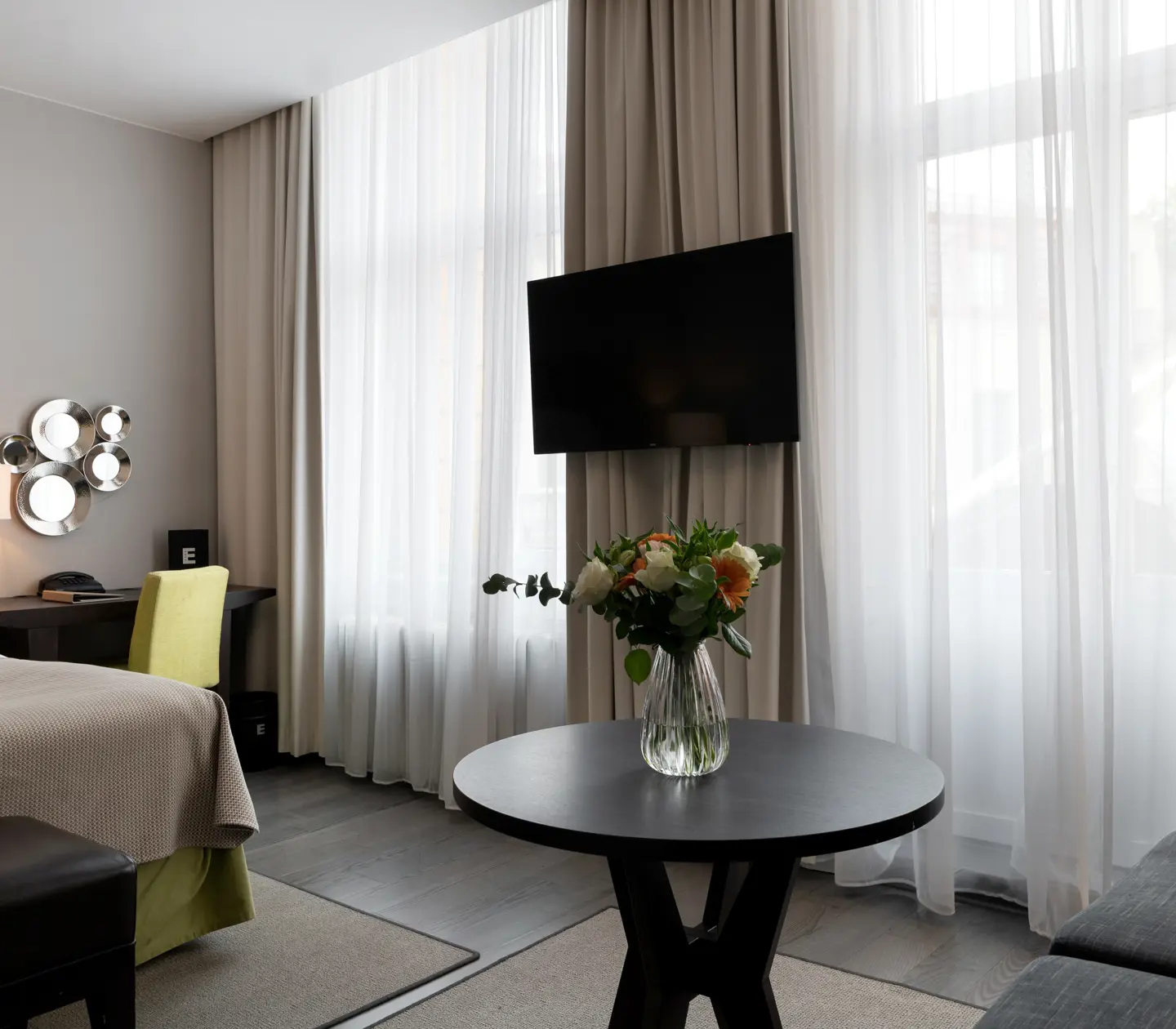 Hotellrum med soffa, fönster och skrivbord