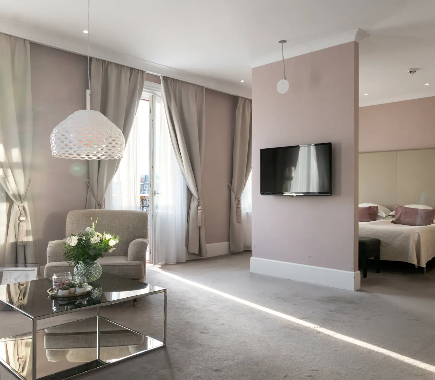 Rosa svit med dubbelsäng, tv och soffgrupp