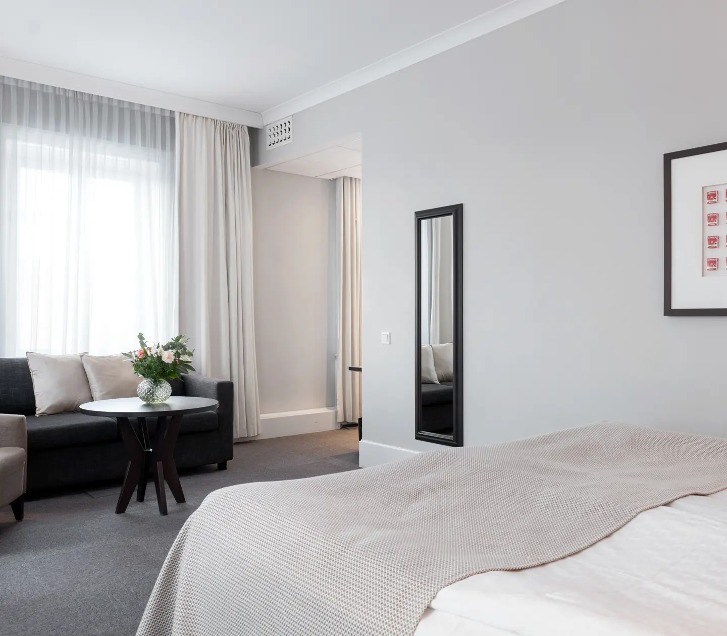Ljus svit med soffgrupp, spegel och fönster