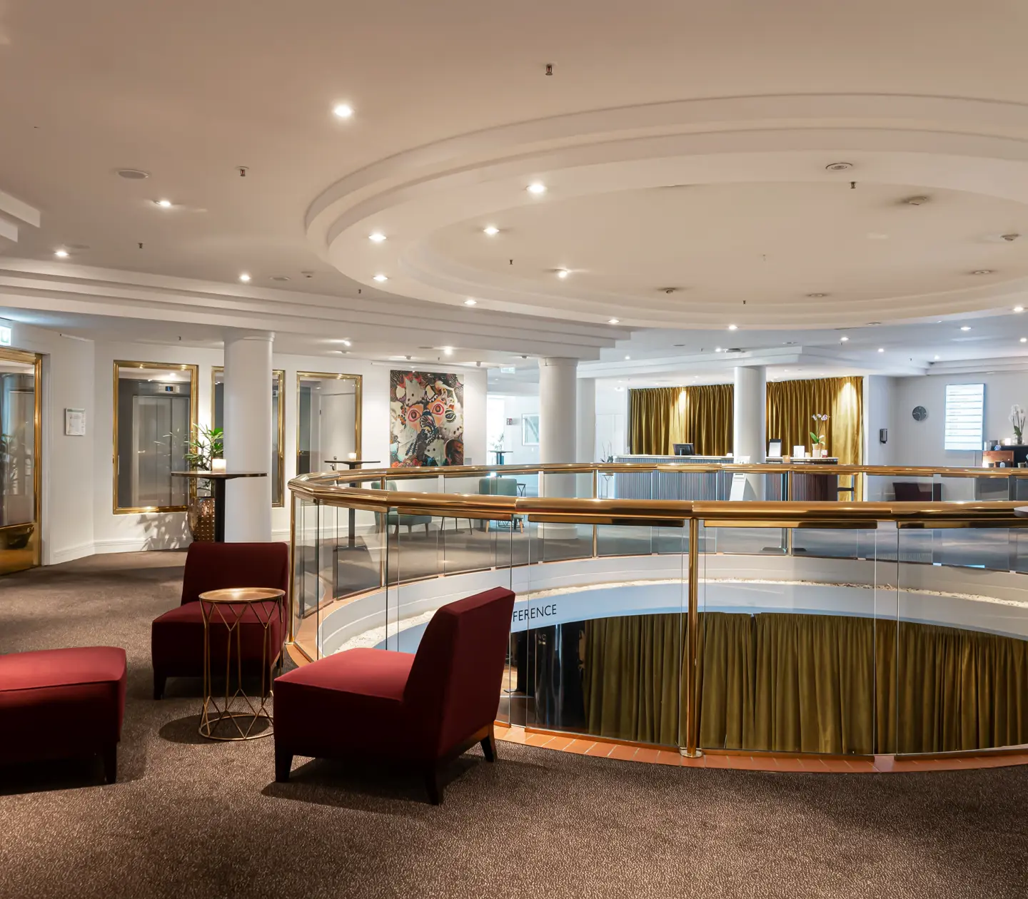 Hotellmiljö med öppning ner till undervåningen och sittgrupper