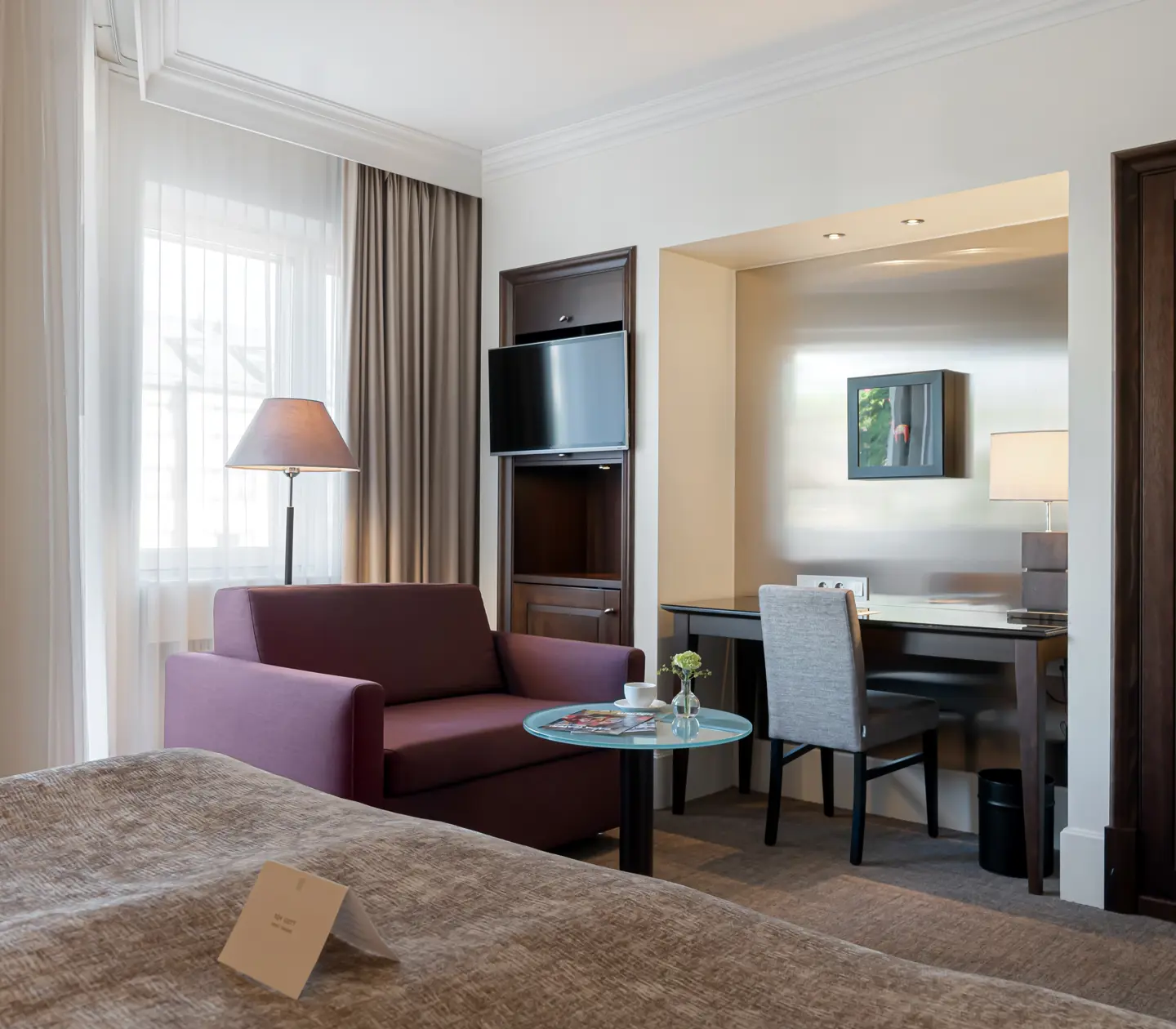 Hotellrum med soffa, skrivbord och tv