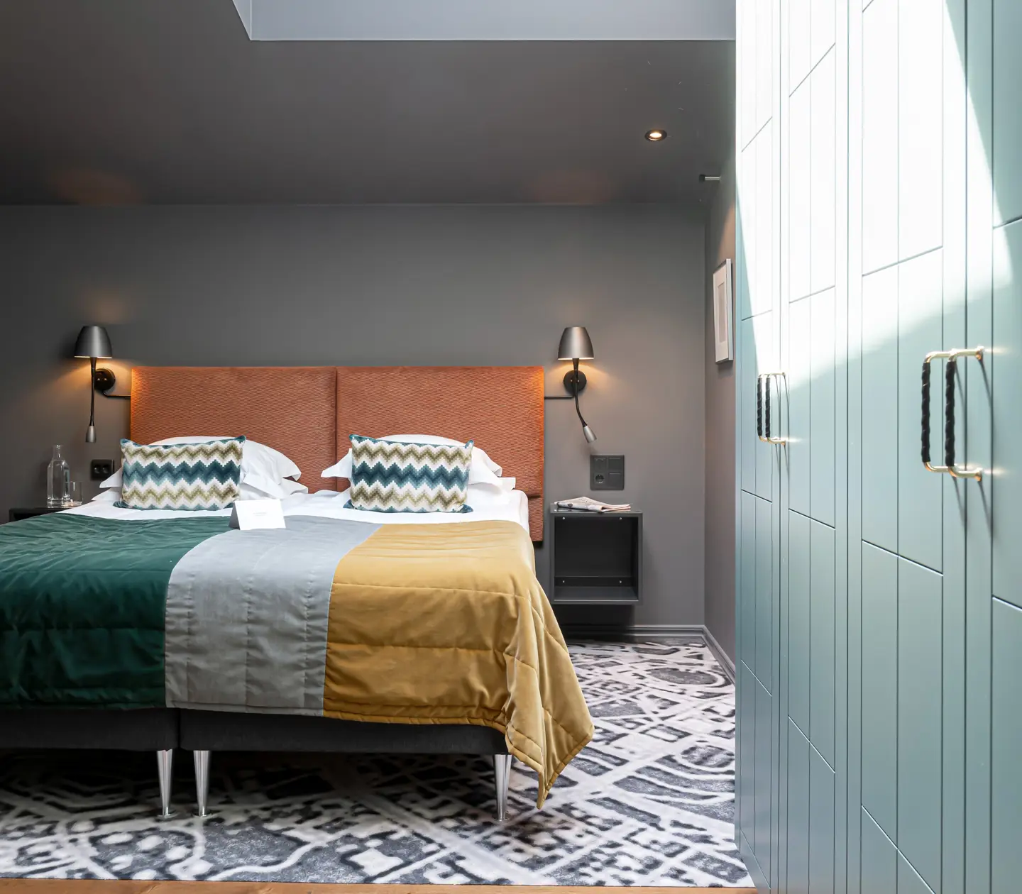 Färgglatt hotellrum med dubbelsäng och garderober