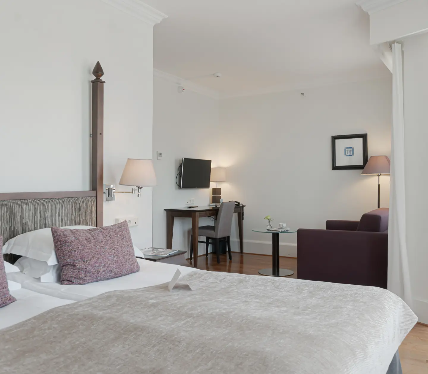 Mysigt hotellrum med dubbelsäng, fåtölj och skrivbord
