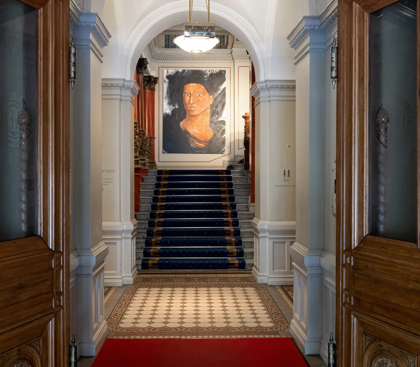Hotellmiljö med trappa och tavla av ansikte