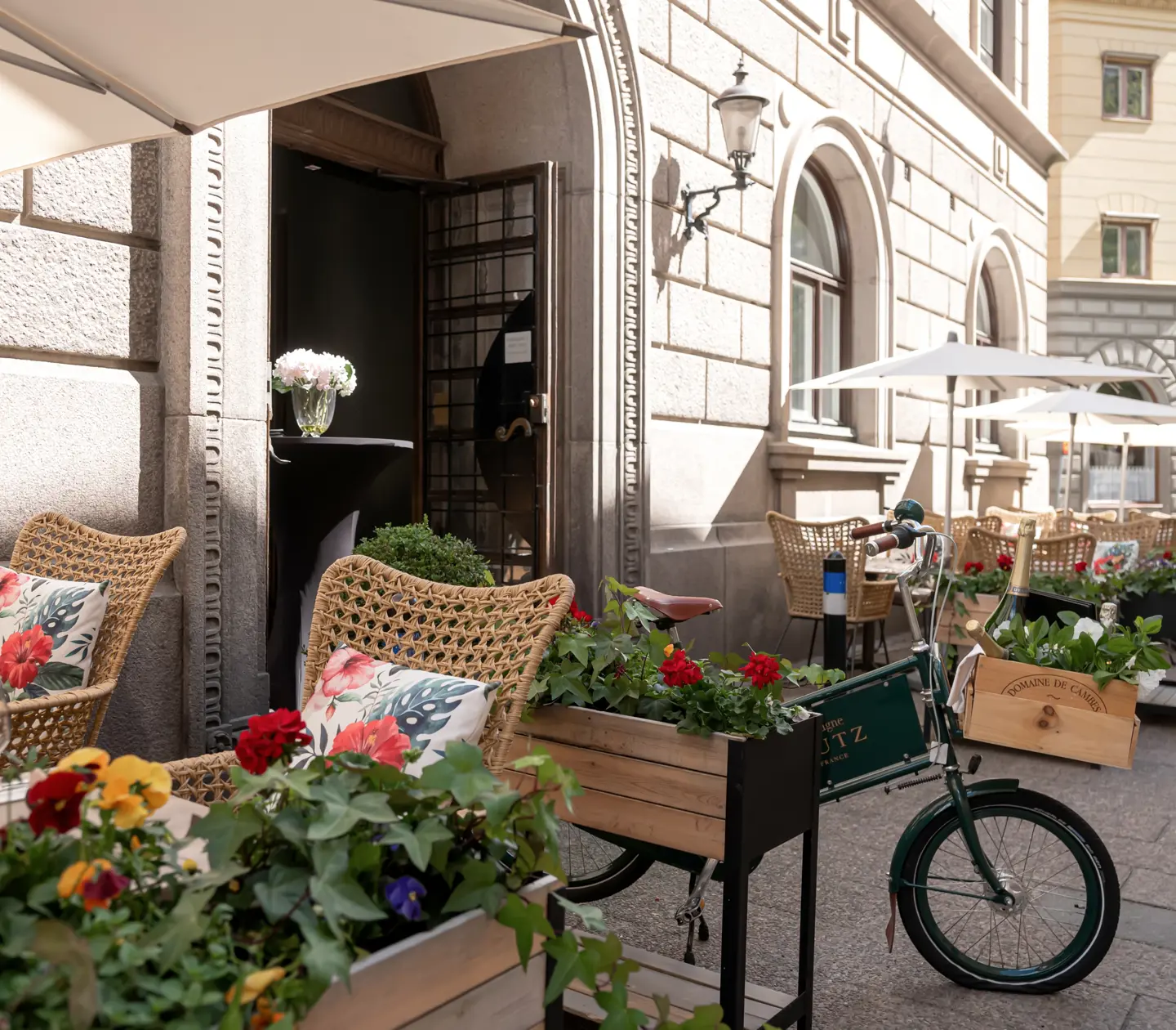 Uteservering med blommor, parasol och sittgrupper