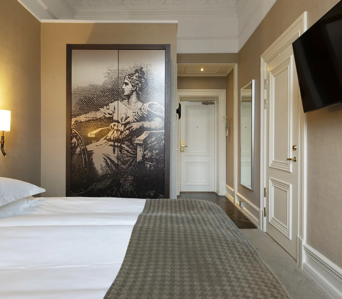 Hotellrum med säng, stor sänggavel och garderob