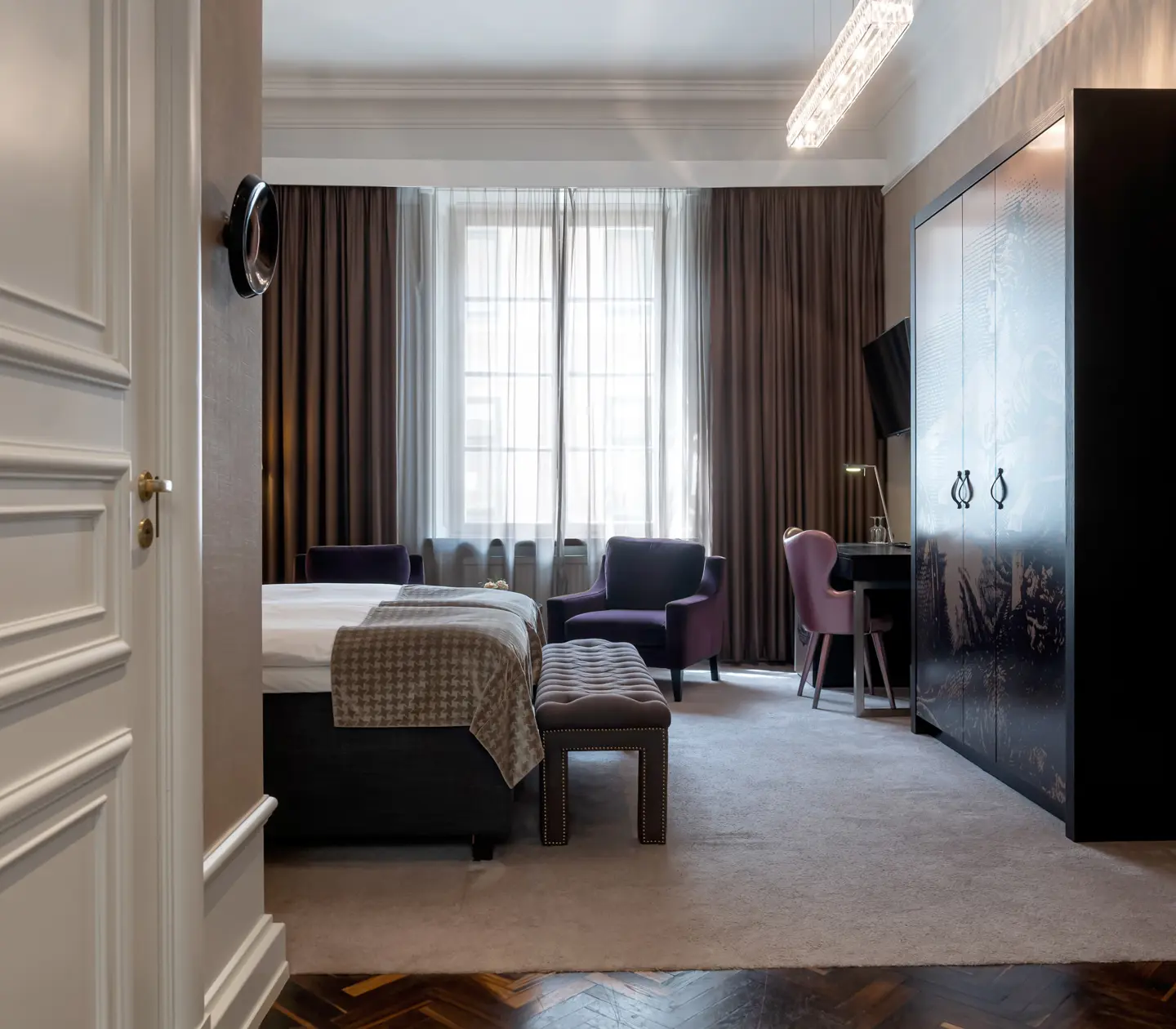 Hotellrum med säng, garderober och skrivbord