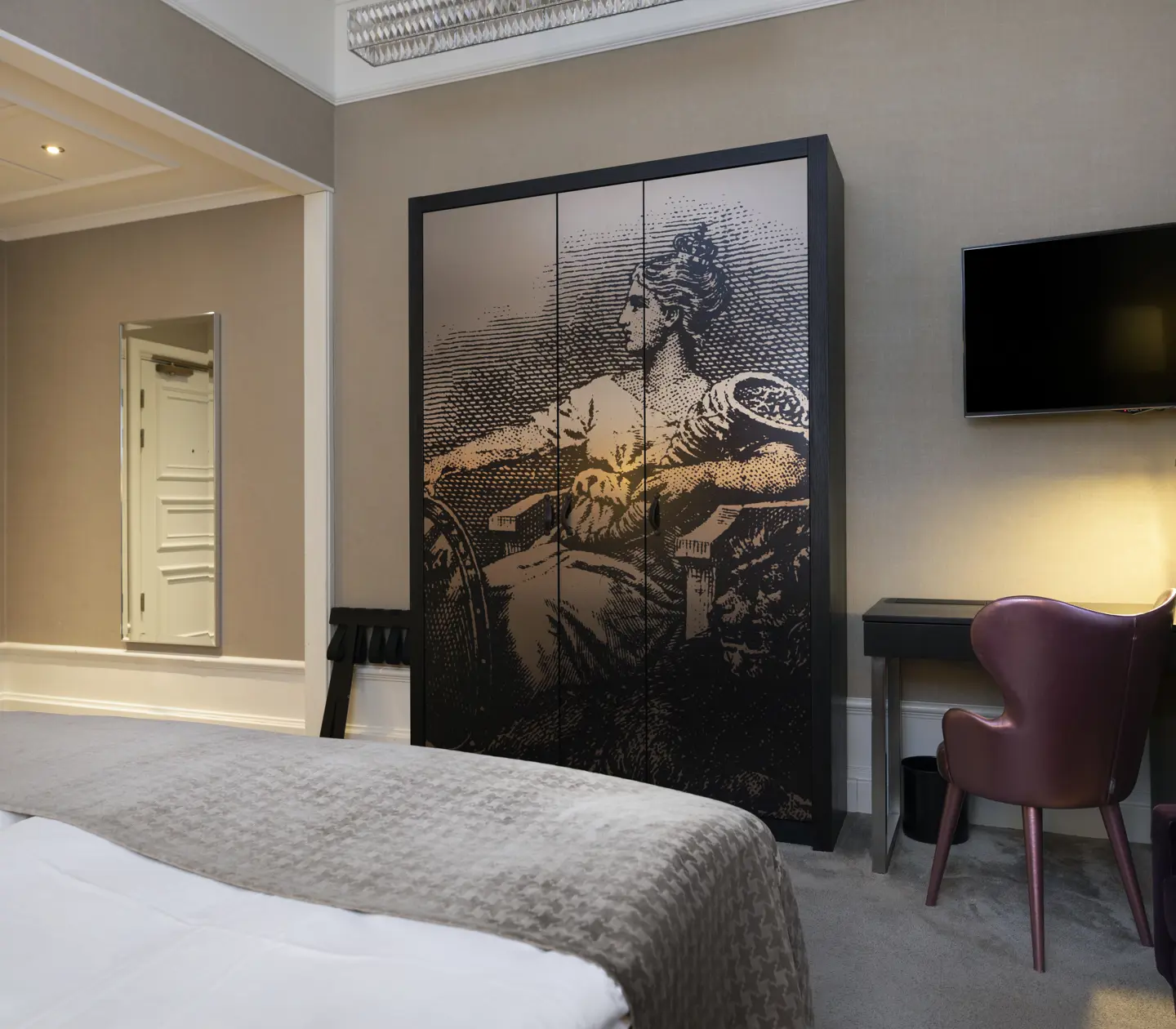 Hotellrum med skrivbord, garderob och spegel