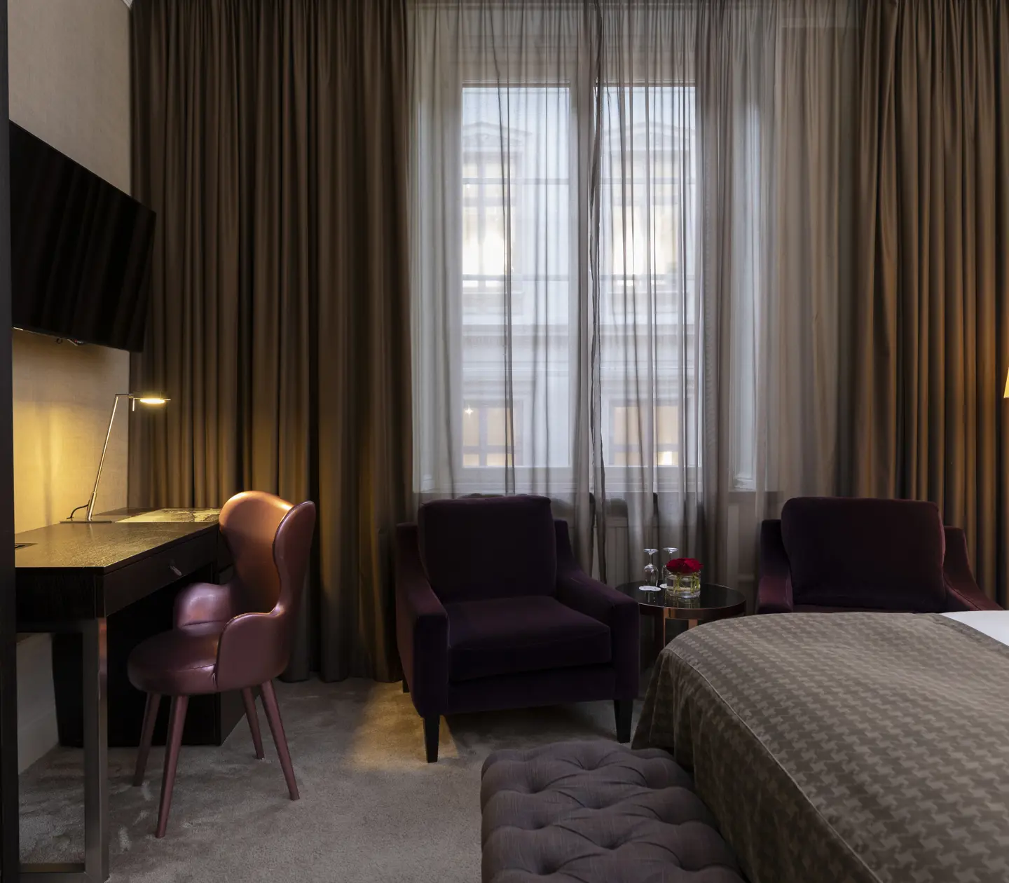 Hotellrum med fåtöljer, skrivbord och tv