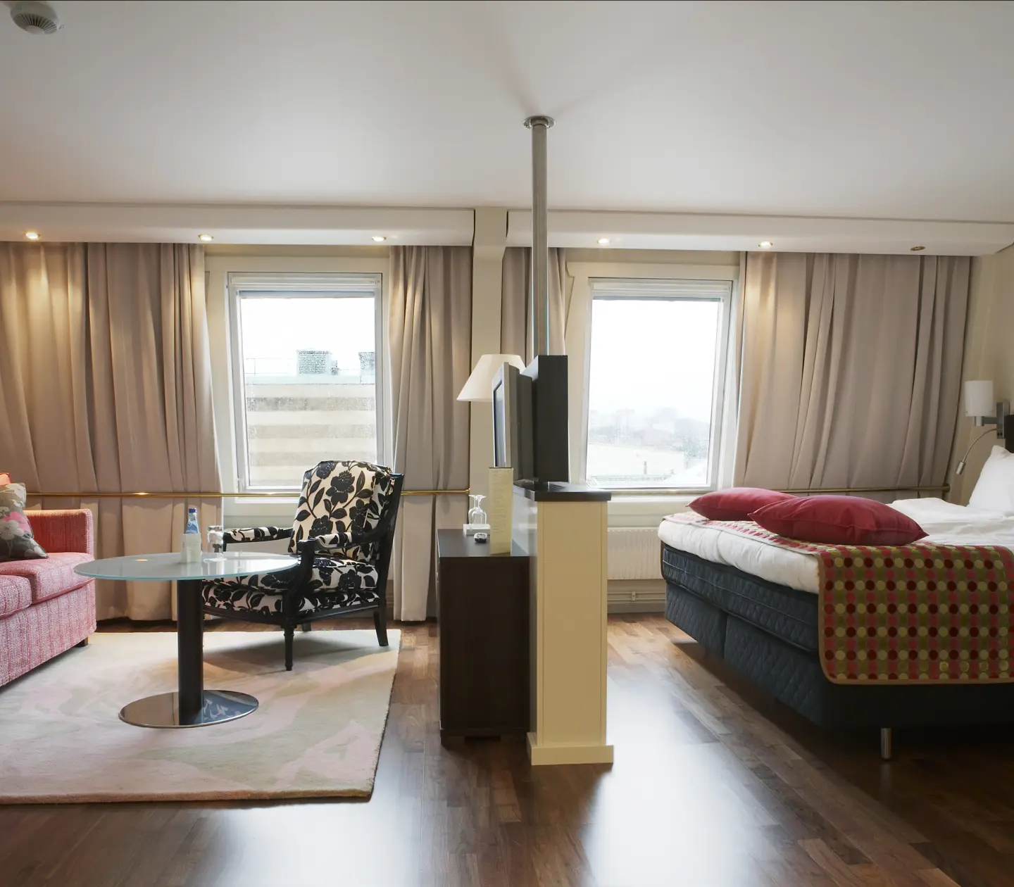 Hotellrum med säng, soffgrupp och fönster