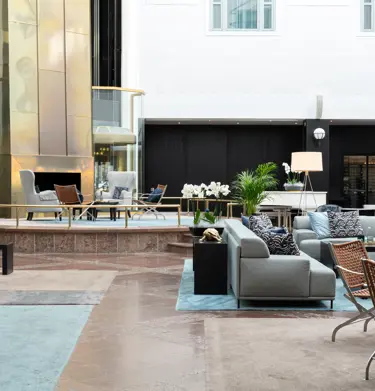 Ljus hotellobby med soffgrupper och växter