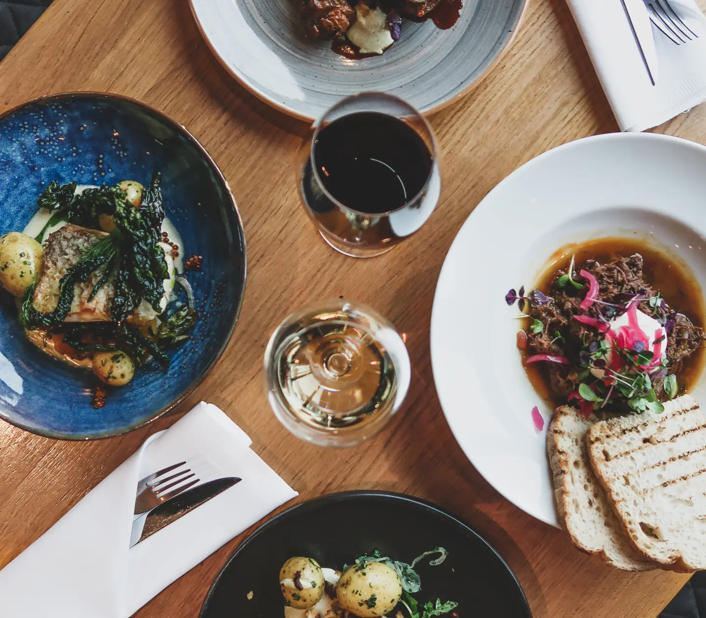 Mat fotad uppifrån med bröd och vin i glasen